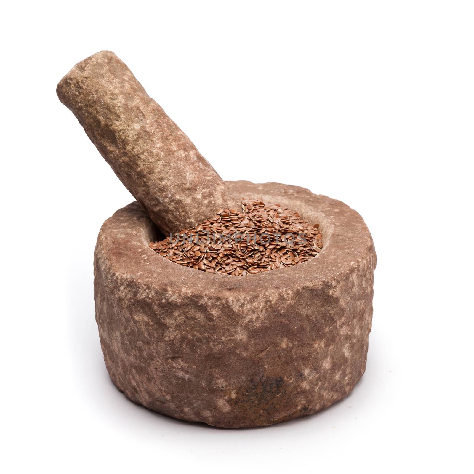 Organic Linseed or Flaxseed (Linum usitatissimum) in mortar with pestle, isolated on white background.