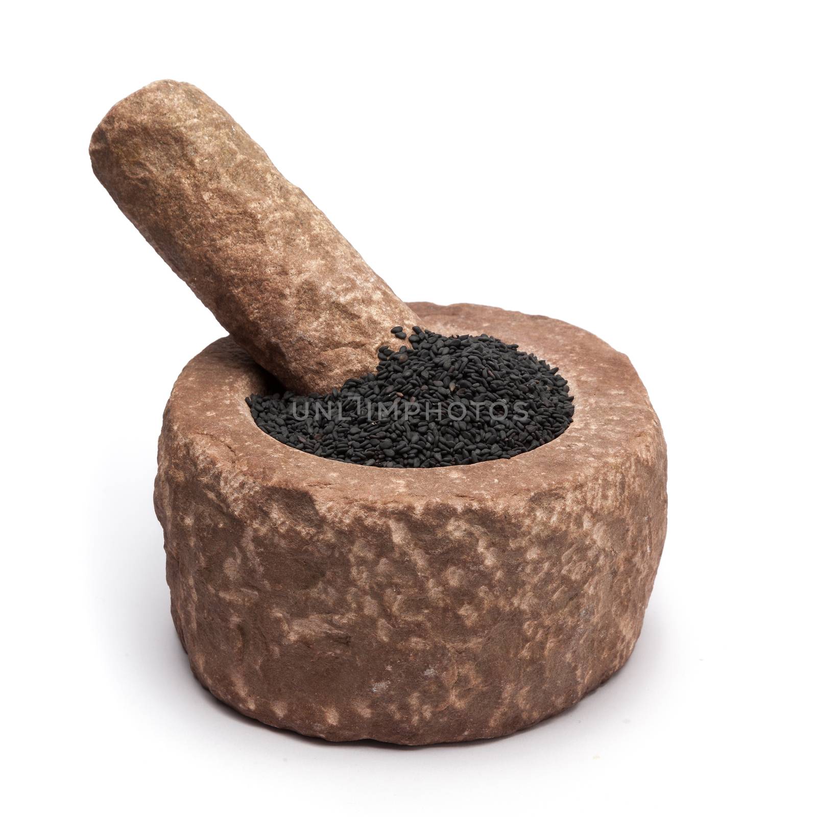 Organic Black Sesame (Sesamum indicum) in mortar with pestle, isolated on white background.