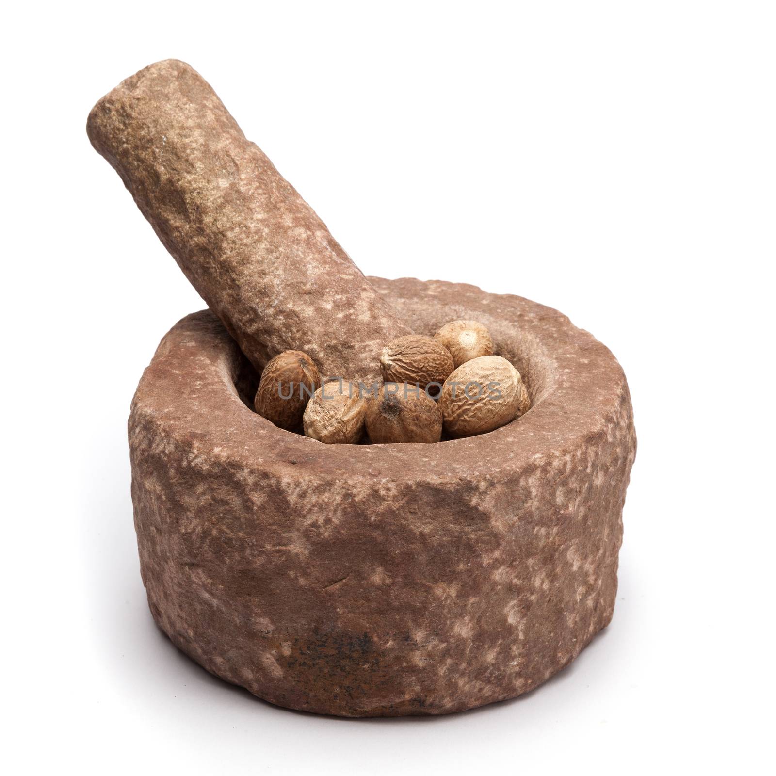Organic Nutmeg Seed or Jaiphal (Myristica fragrans) in mortar with pestle, isolated on white background.