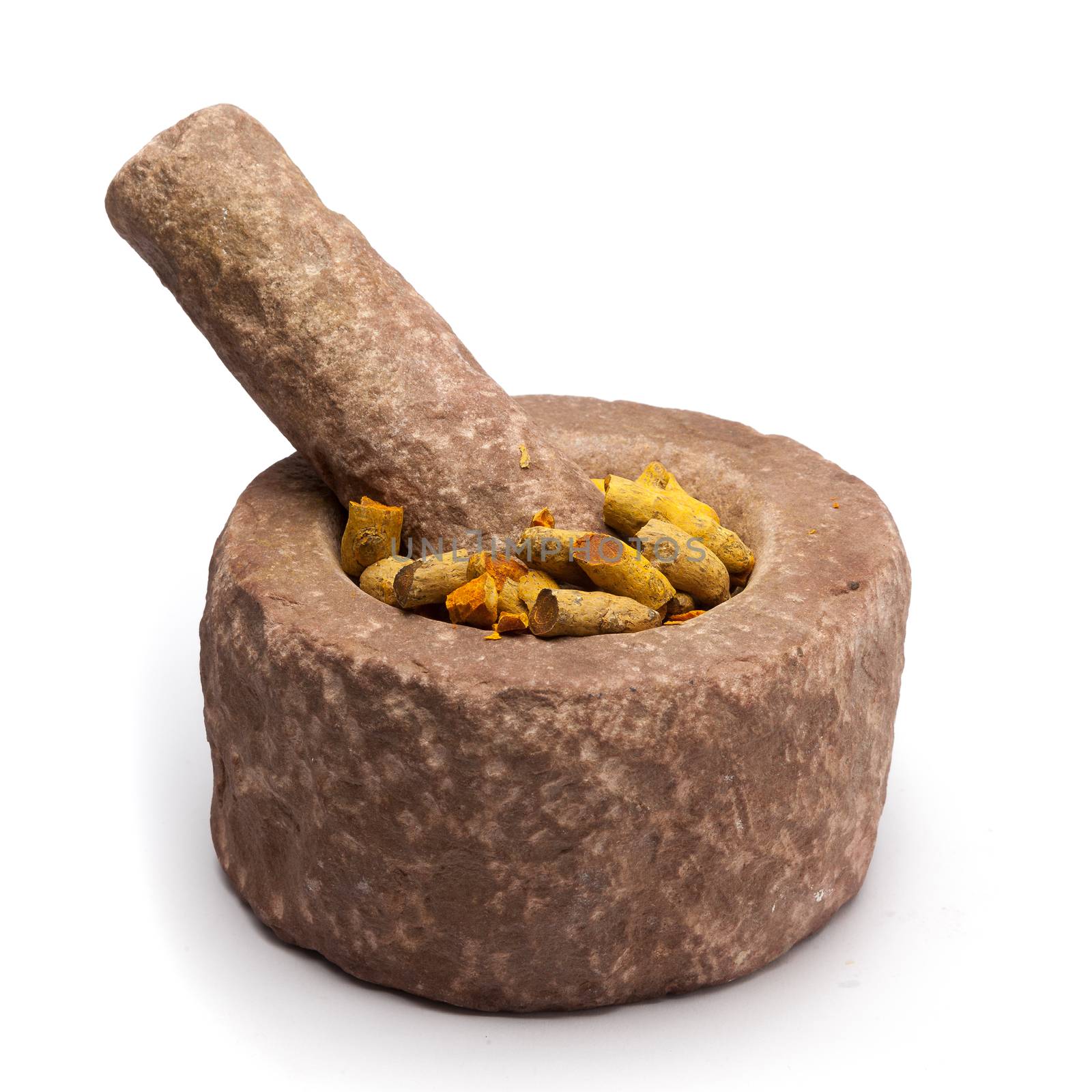 Full and cracked Organic Long Turmeric or Haldi (Curcuma longa) in mortar with pestle, isolated on white background.