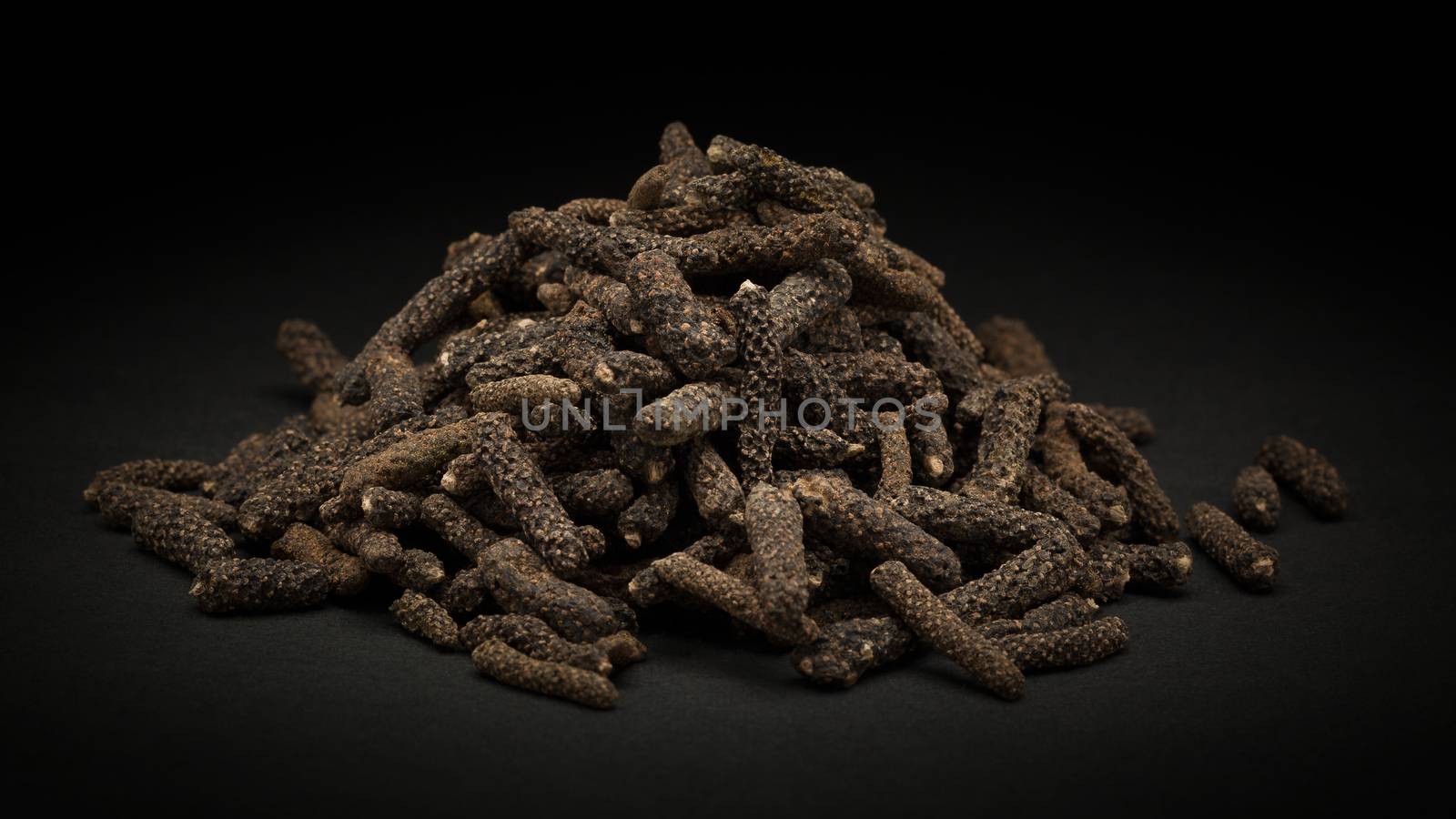 Pile of Organic Long pepper Dried Fruit (Piper longum) by ziprashantzi