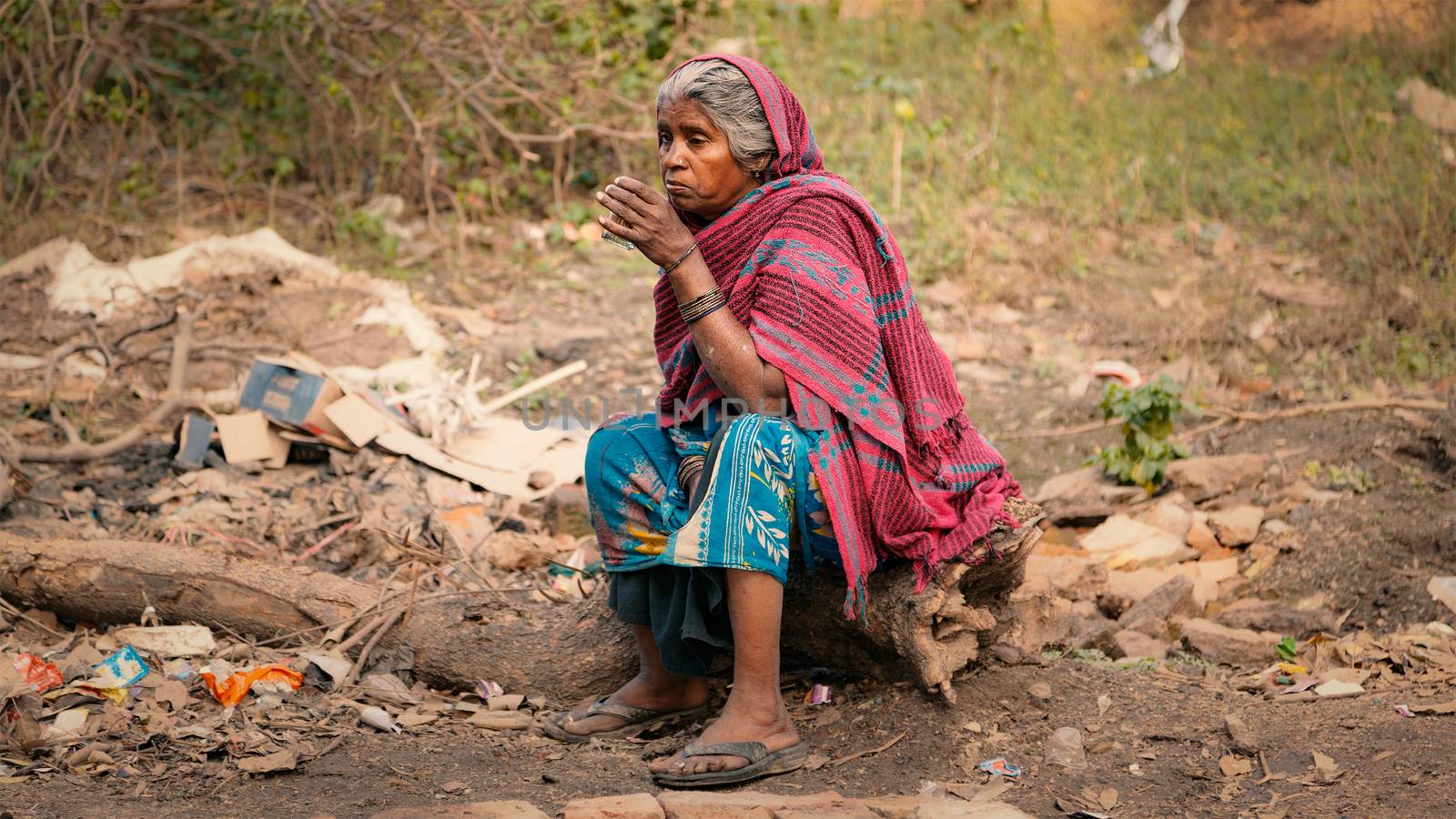 An Old female Indian beggar sitting and having tea. by ziprashantzi