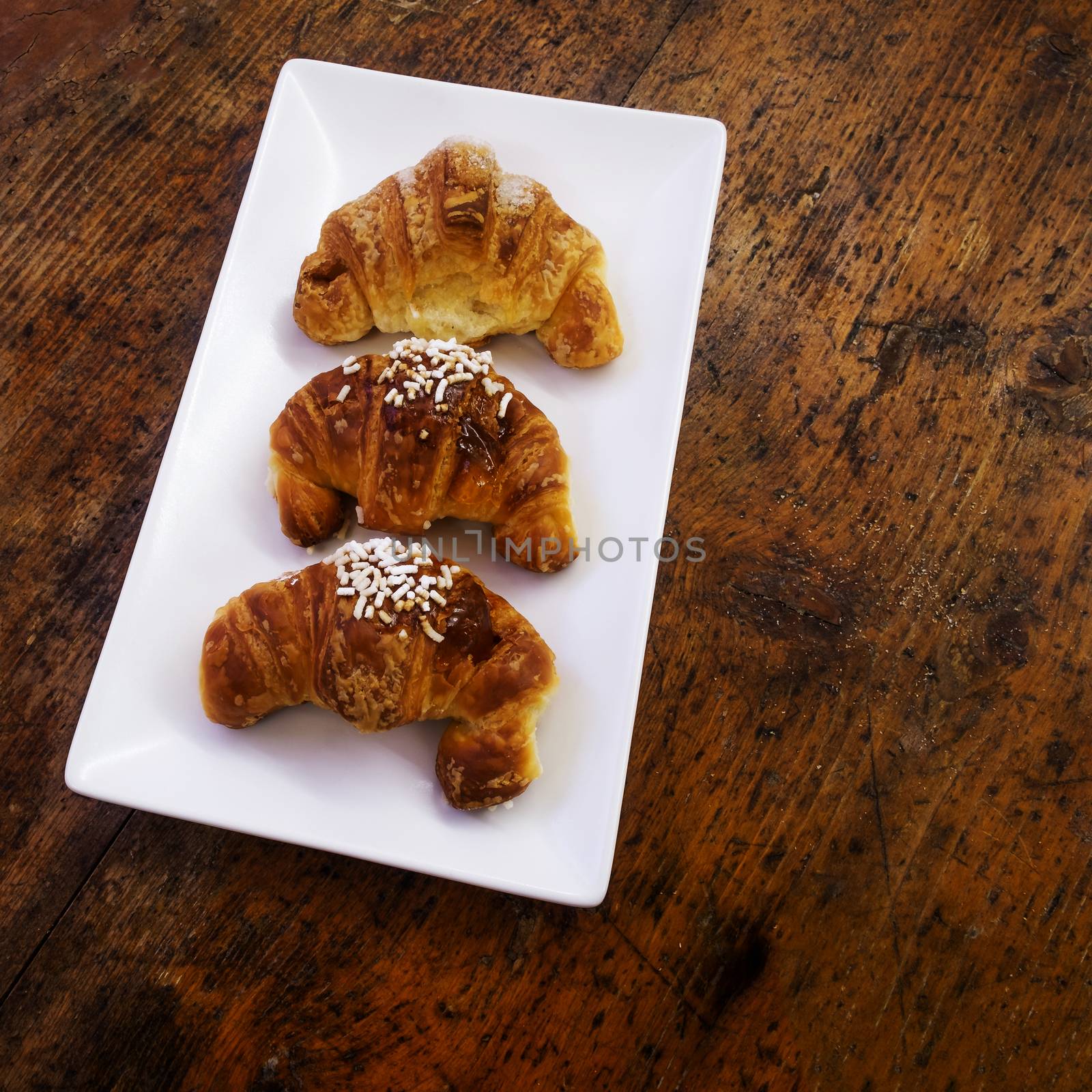 three sweet croissant on a rectangualr white dish