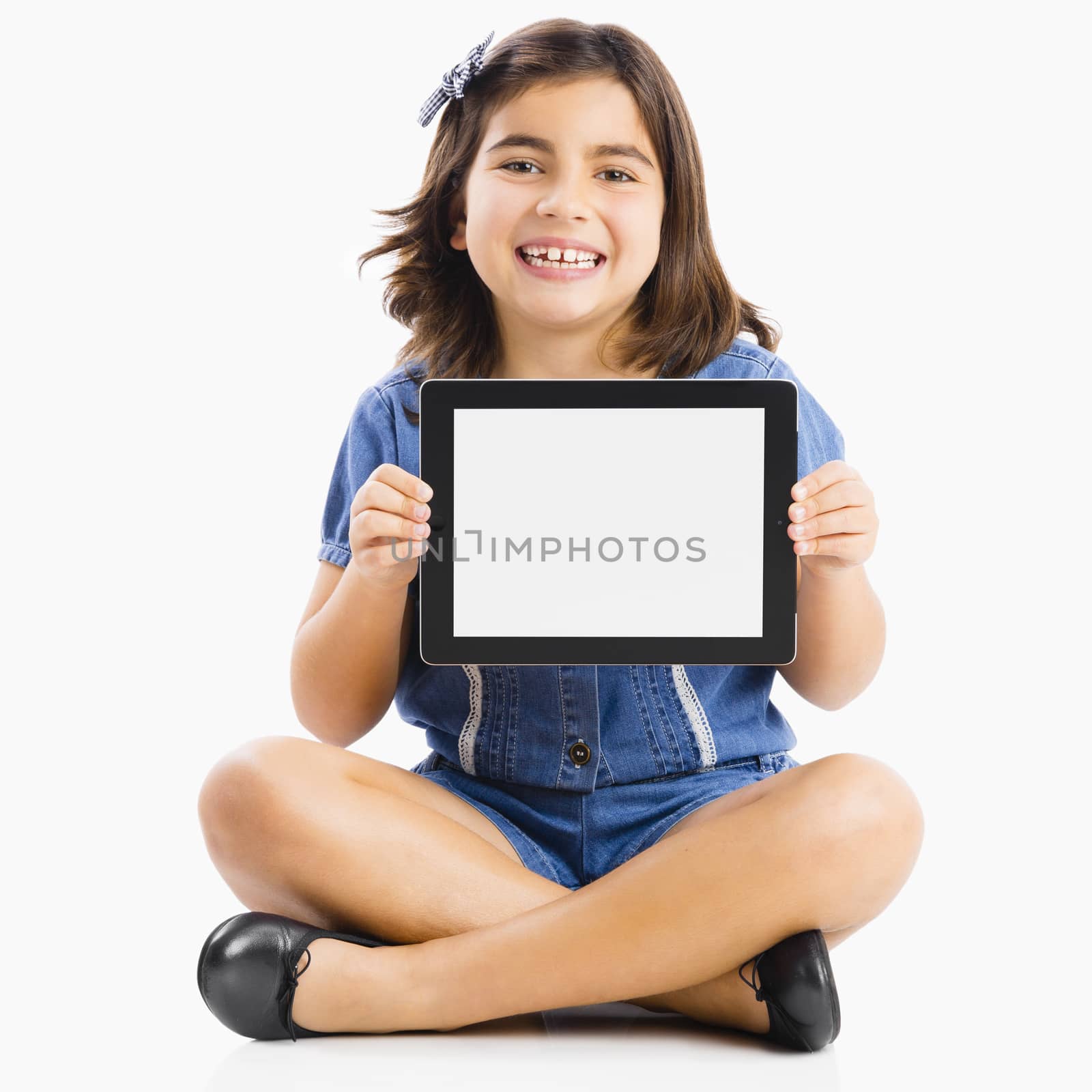 Young girl sitting on floor and showing something on a tablet