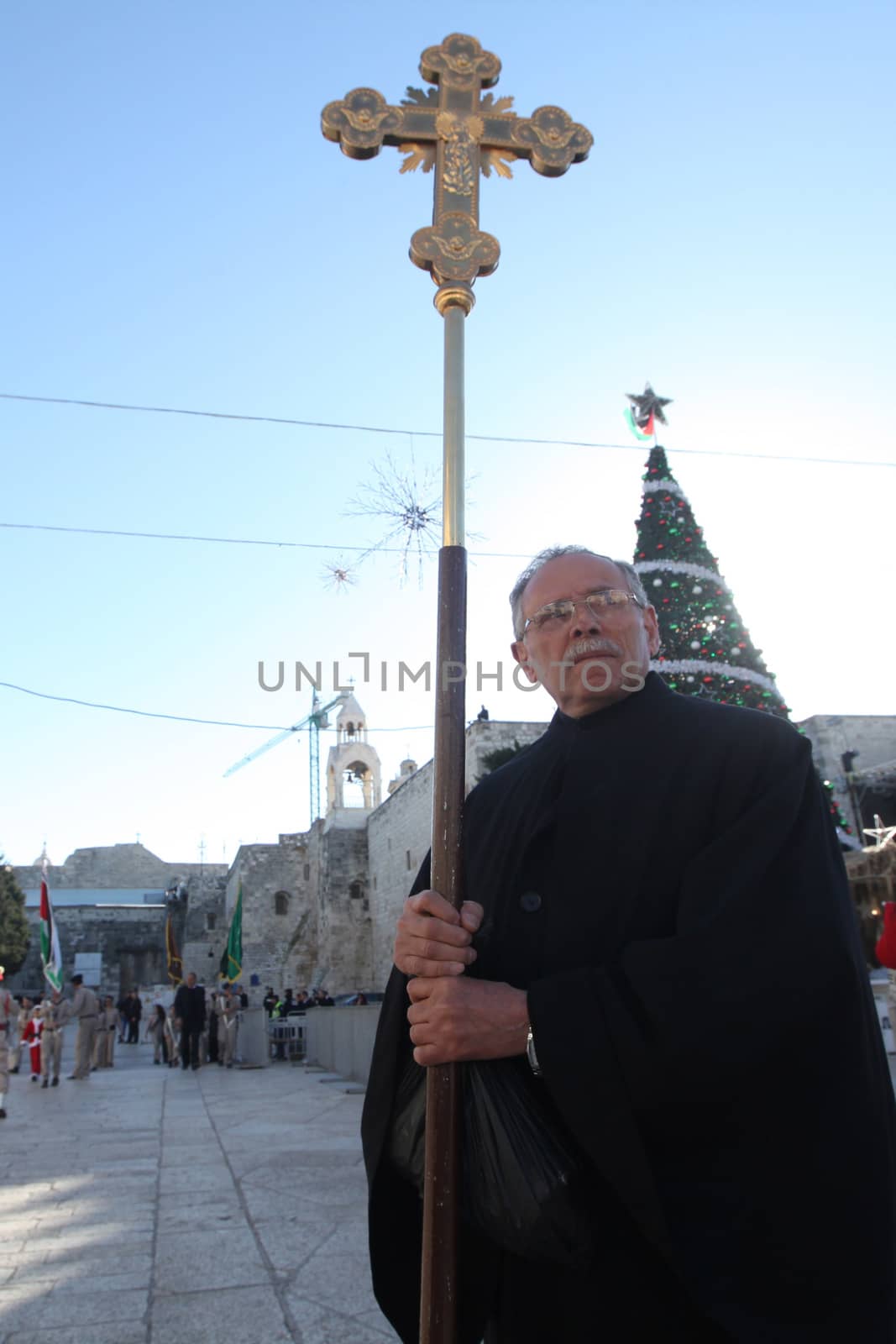 WEST BANK, Bethlehem: An Orthodox Christian Palestinian of holds a cross before the Christmas Eve procession in Bethlehem, the West Bank on January 6, 2016. The celebration is held in accordance with the Julian calendar, which places Christmas on January 7, nearly two weeks after many Christians have celebrated the holiday on December 25.