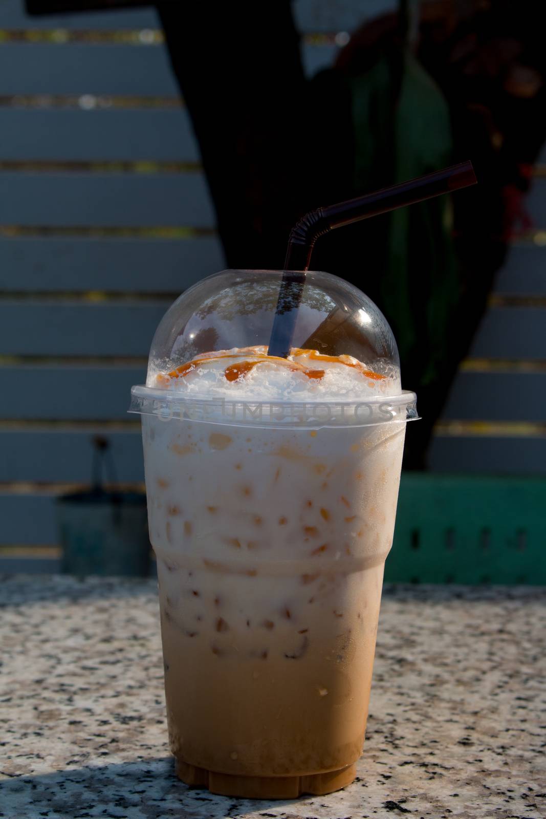 Iced coffee with straw in plastic cup