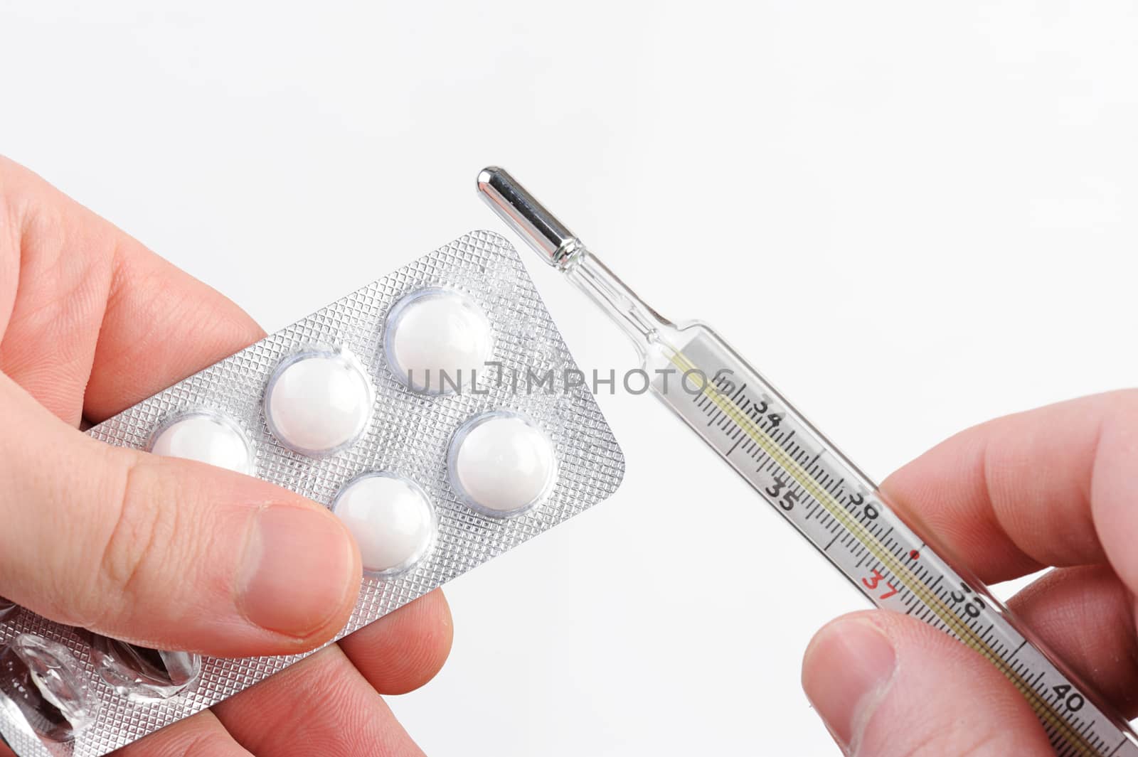 thermometer and pack white round pills on hand