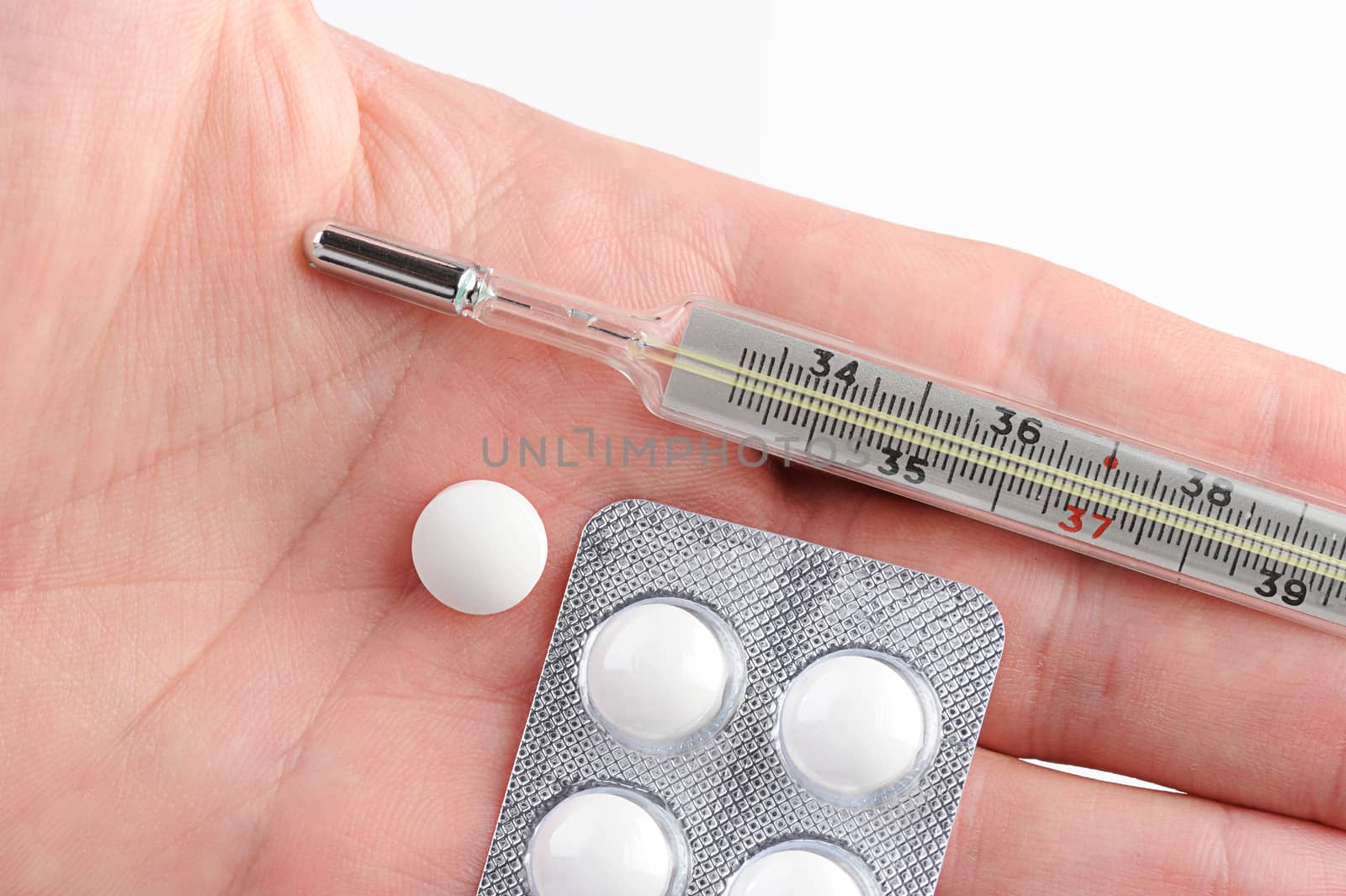 pill from flu and cold on hand on white background