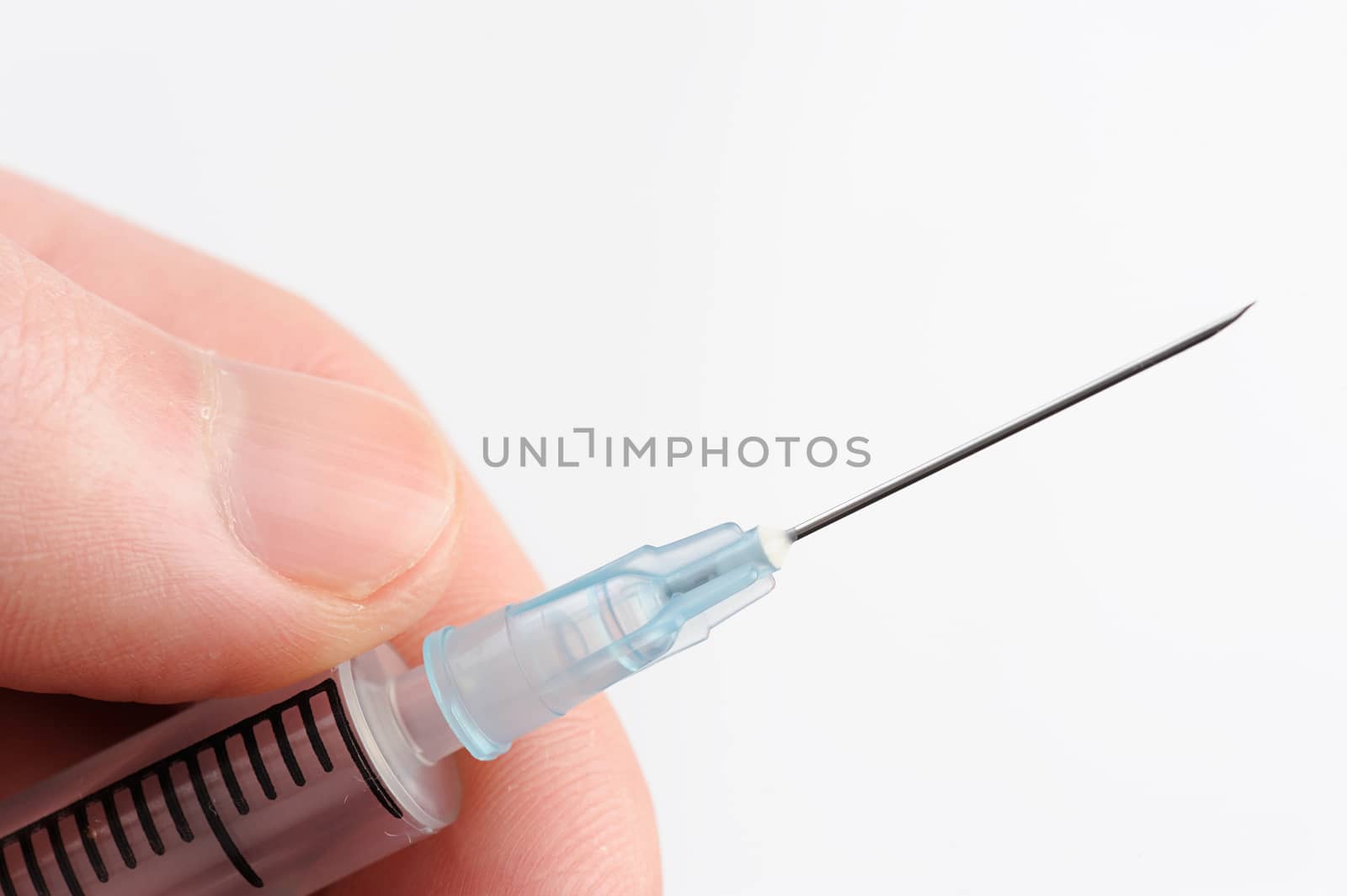 macro of syringe with needle in hand on white
