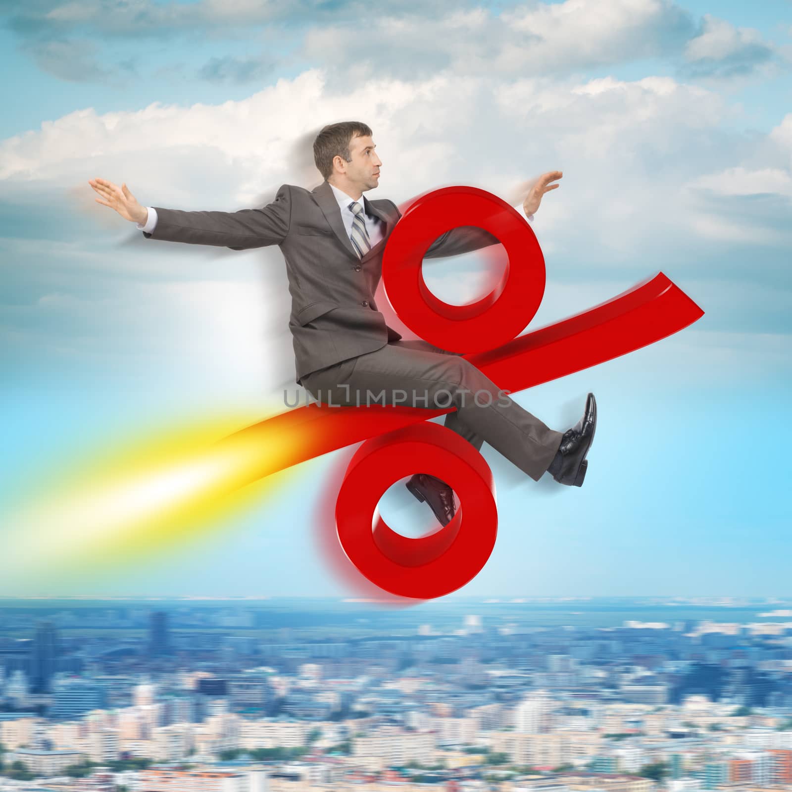 Businessman flying on percent sign above city