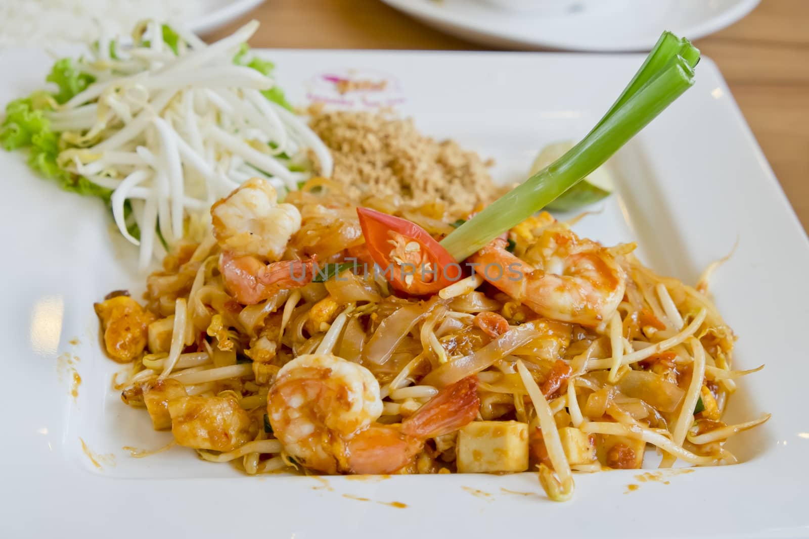 Delicious rice noodles with shrimp close-up on a plate. Thai Dis by art9858