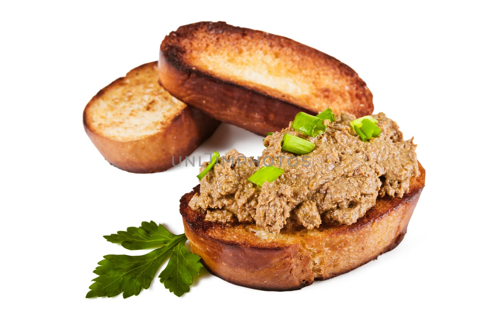 Fried bread with liver pate, green onions and parsley leaves on a white background