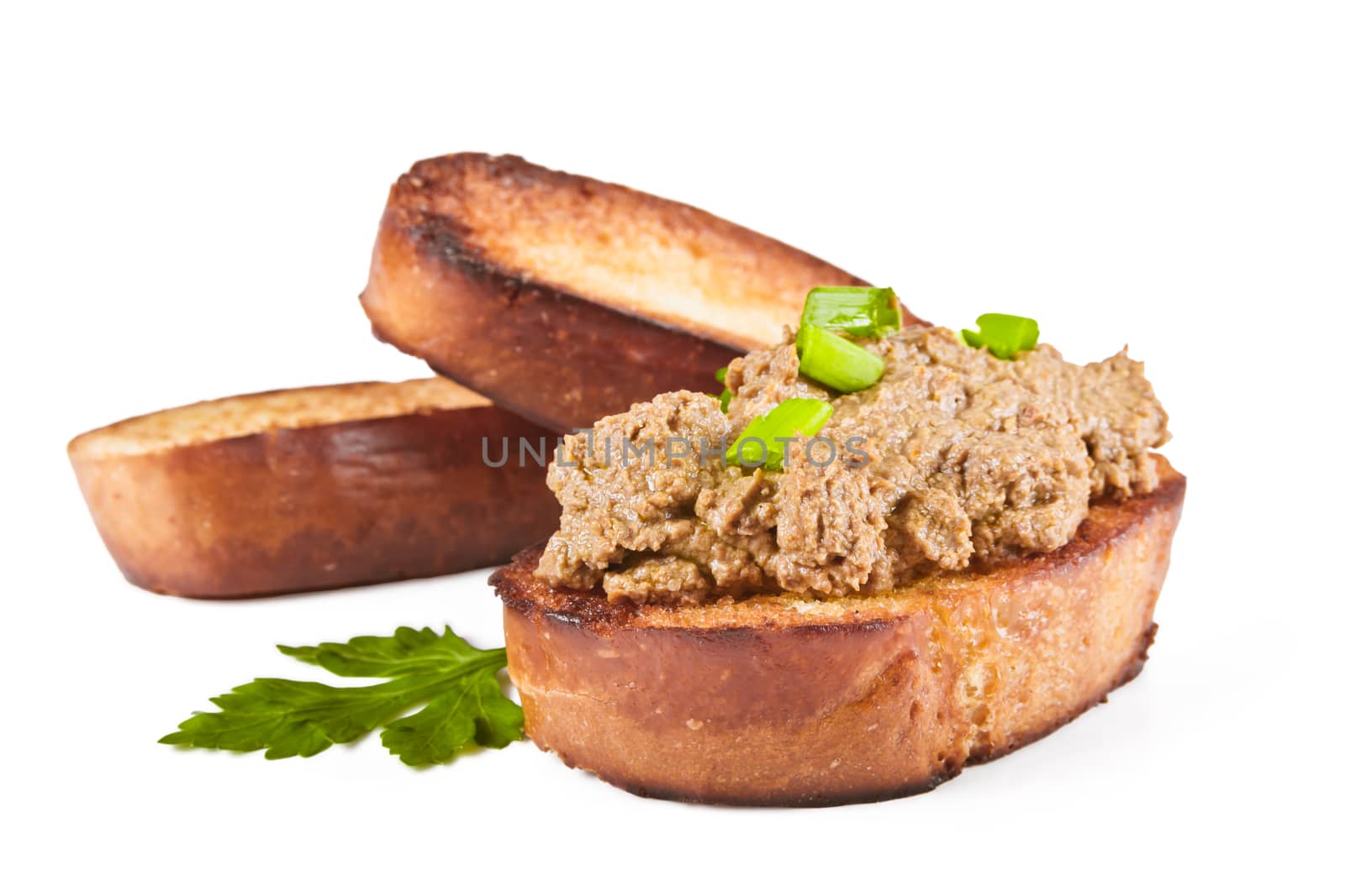 Fried bread with liver pate, green onions and parsley leaves on a white background