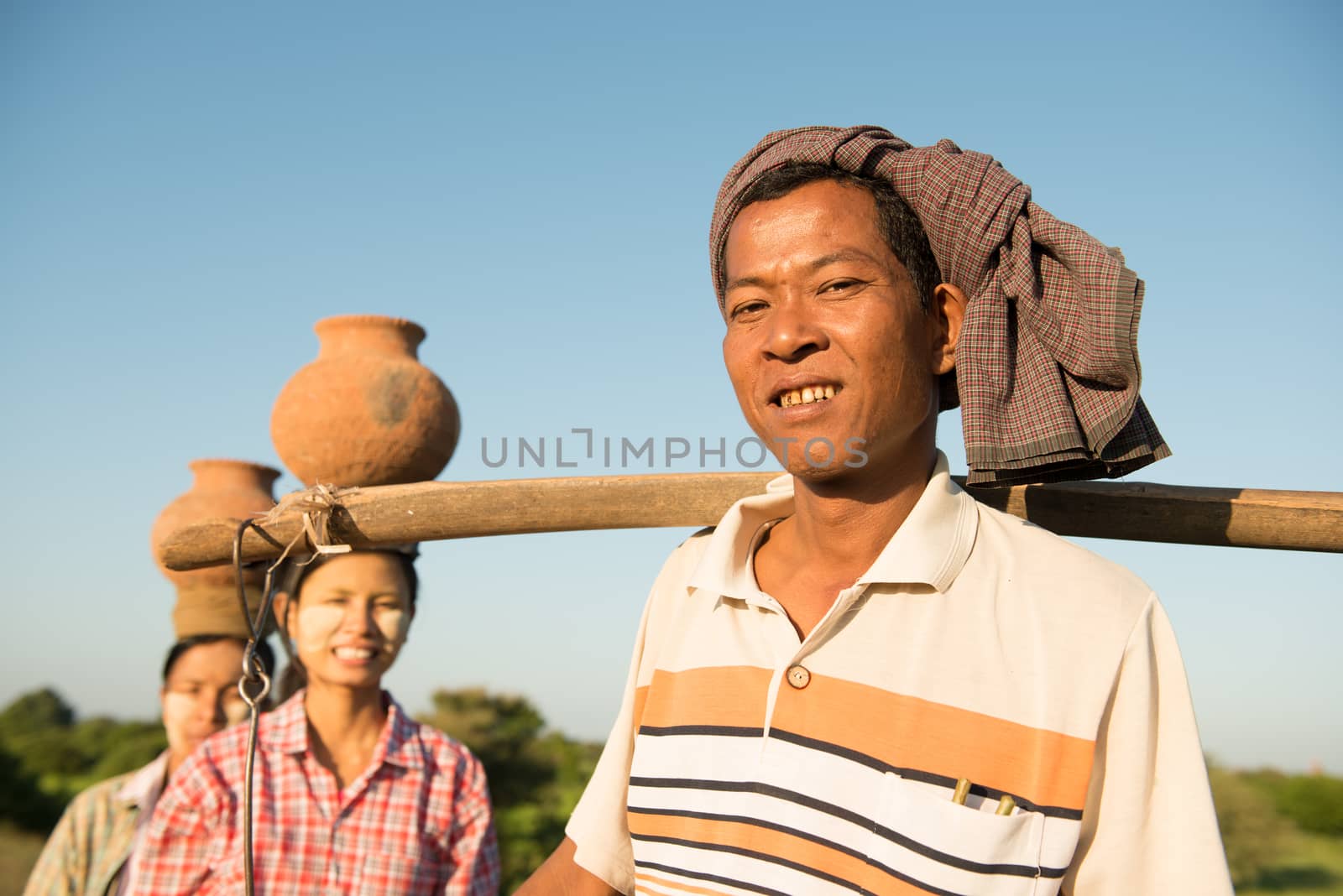 Portrait of group Asian Burmese traditional farmers carrying clay pots on head, Bagan, Myanmar