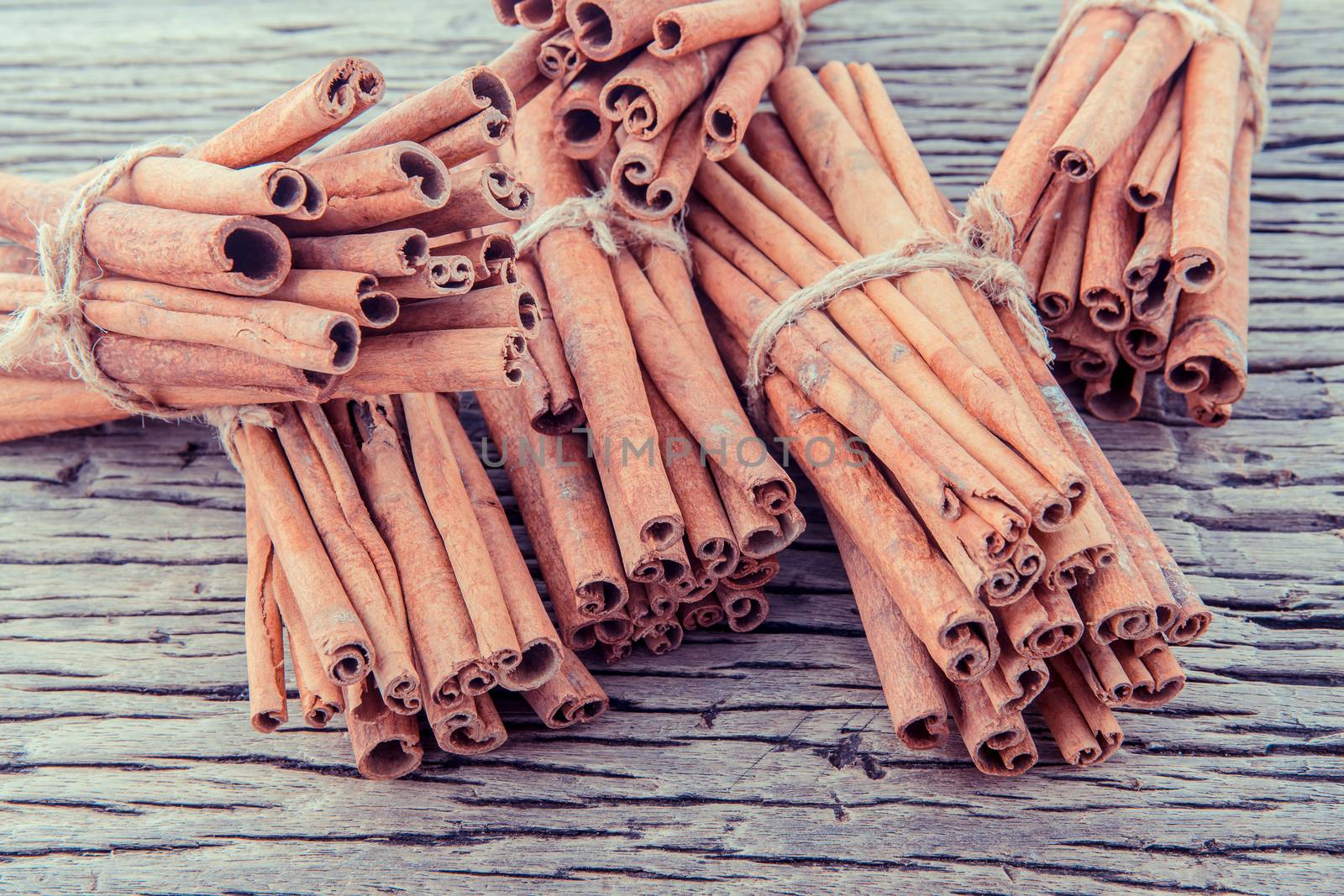 Tied Cinnamon stick with selective focus on old wooden background .