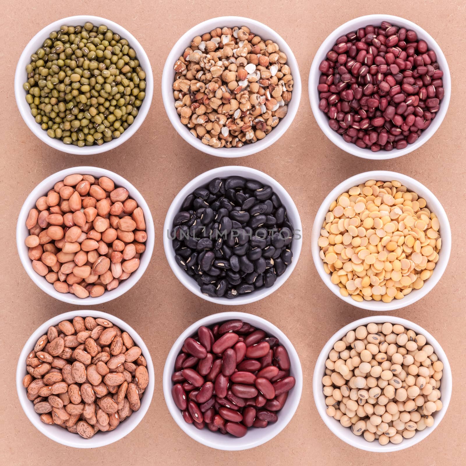 Mixed beans and lentils in the white bowl  on brown background.  by kerdkanno