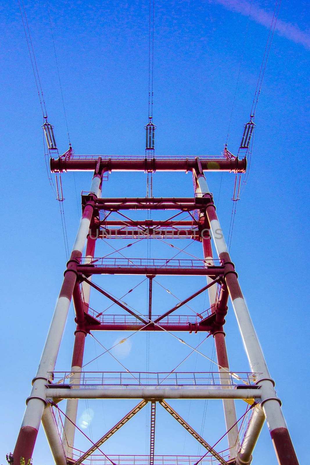 supports of high-voltage power lines against the blue sky