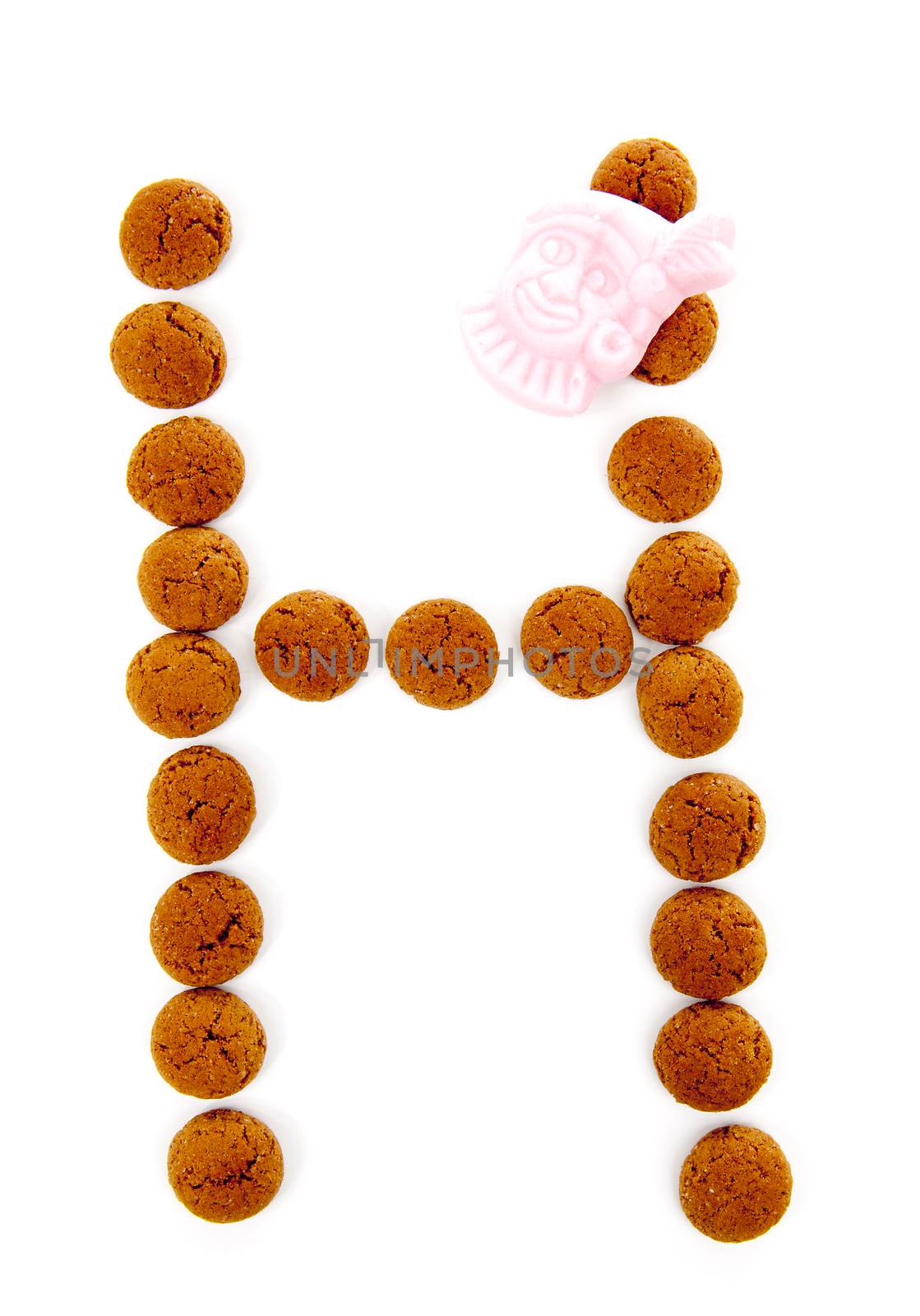 Ginger nuts, pepernoten, in the shape of letter H isolated on white background. Typical Dutch candy for Sinterklaas event in december