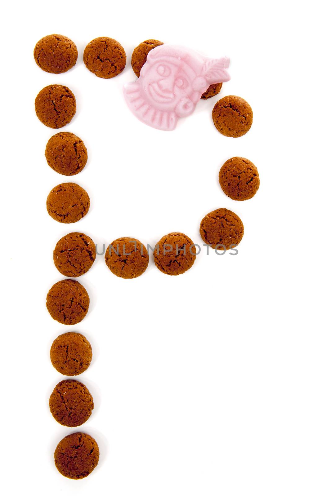 Ginger nuts, pepernoten, in the shape of letter P isolated on white background. Typical Dutch candy for Sinterklaas event in december
