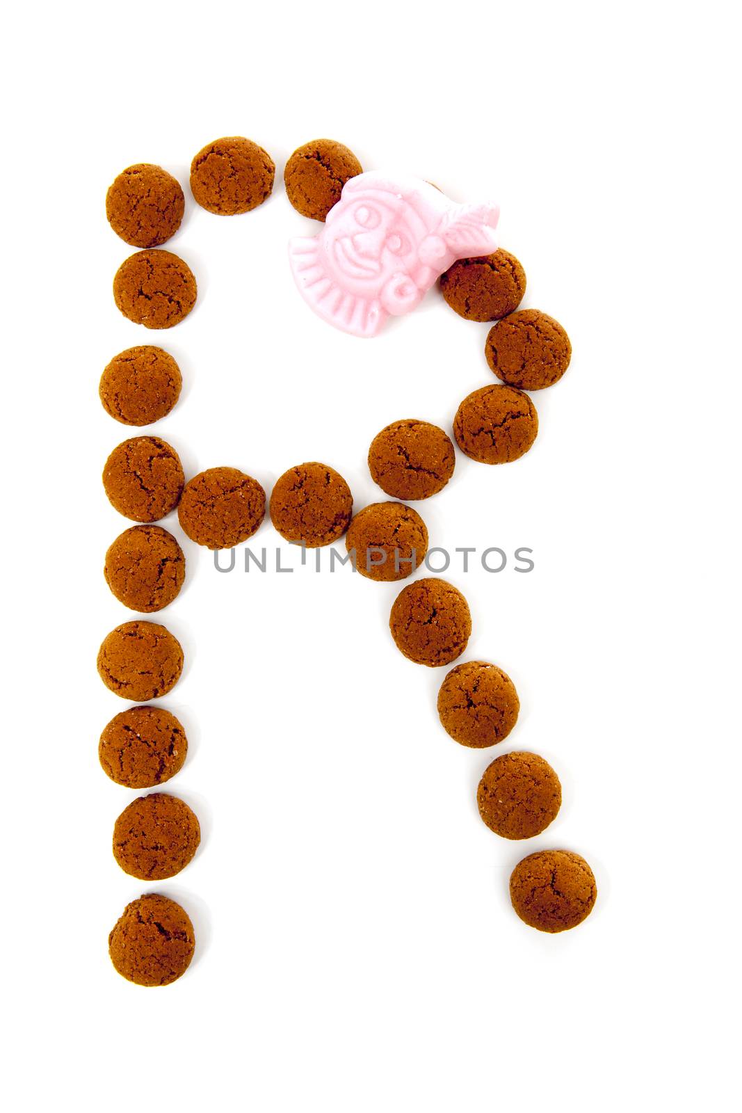 Ginger nuts, pepernoten, in the shape of letter R isolated on white background. Typical Dutch candy for Sinterklaas event in december