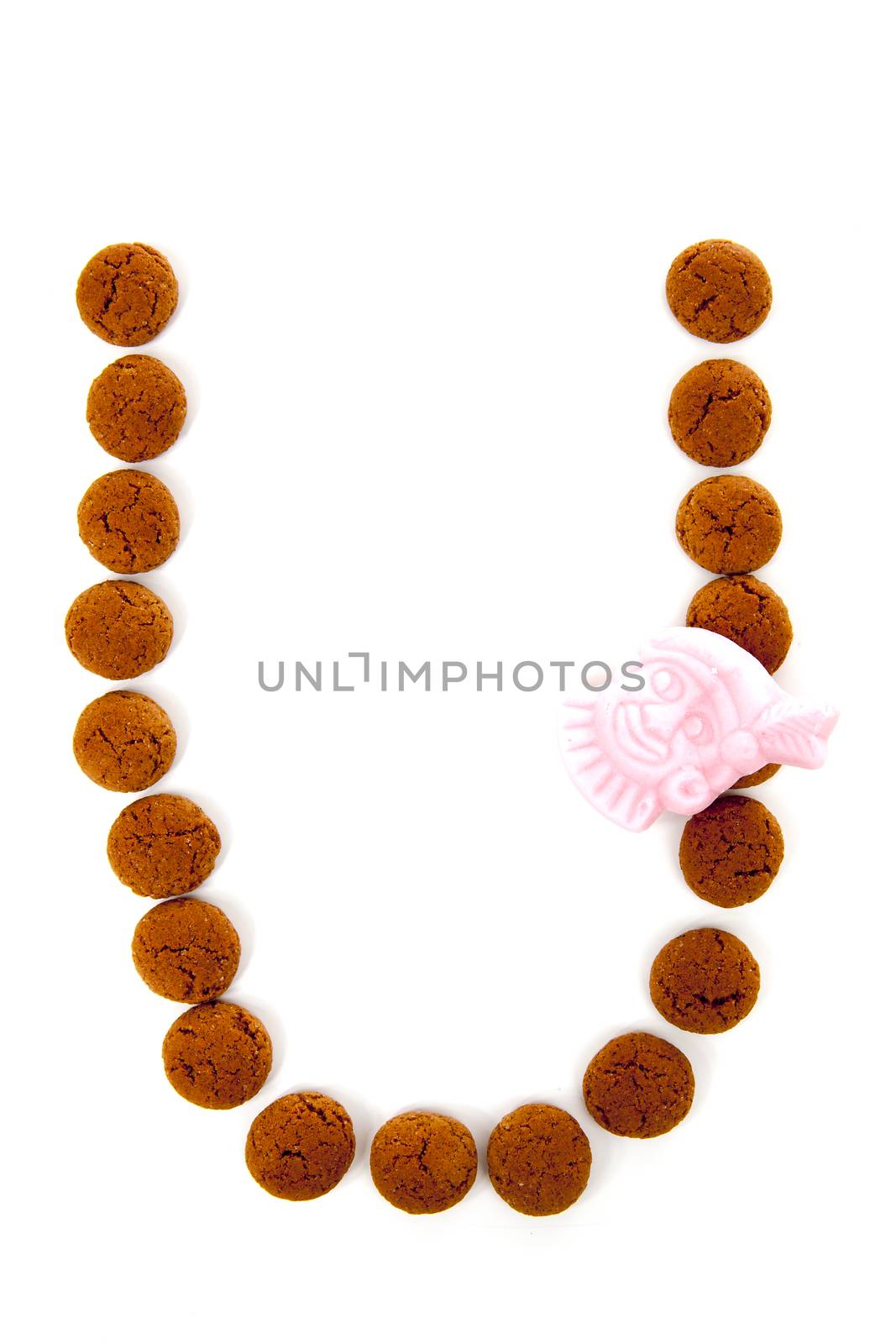 Ginger nuts, pepernoten, in the shape of letter U isolated on white background. Typical Dutch candy for Sinterklaas event in december
