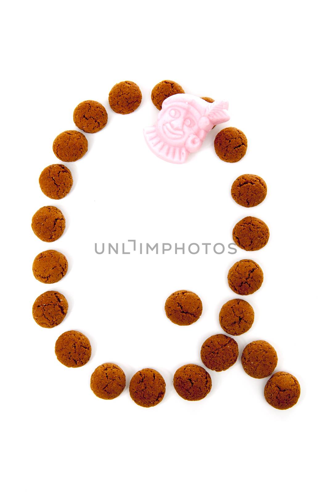 Ginger nuts, pepernoten, in the shape of letter Q isolated on white background. Typical Dutch candy for Sinterklaas event in december