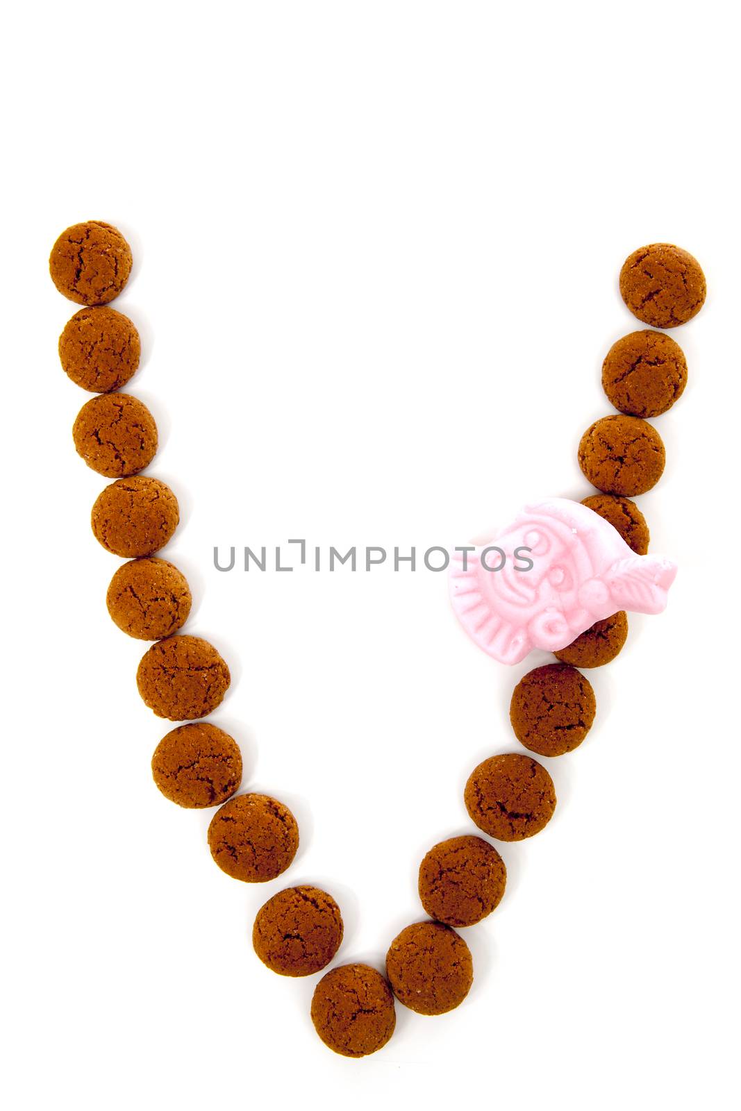 Ginger nuts, pepernoten, in the shape of letter V isolated on white background. Typical Dutch candy for Sinterklaas event in december