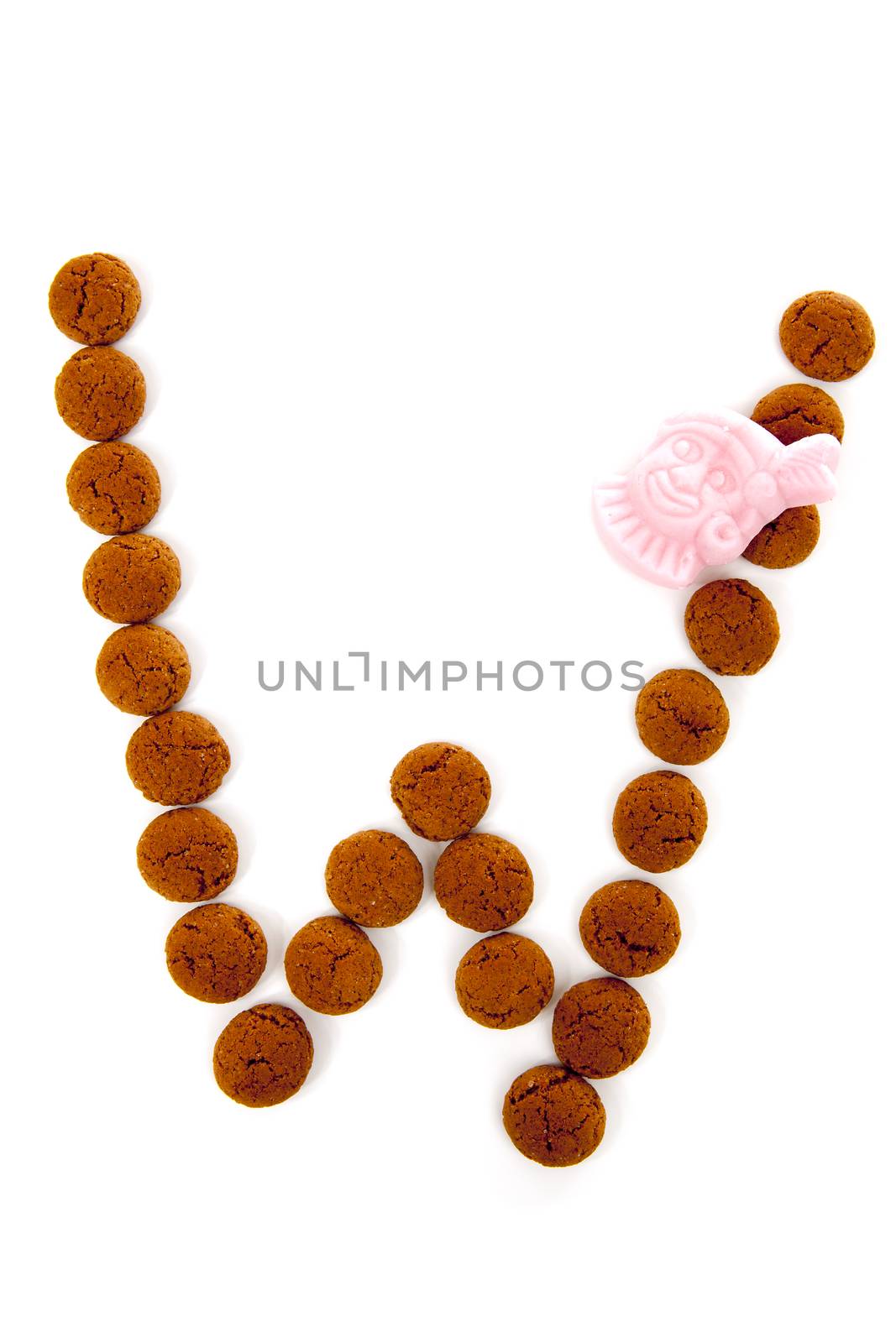 Ginger nuts, pepernoten, in the shape of letter W isolated on white background. Typical Dutch candy for Sinterklaas event in december