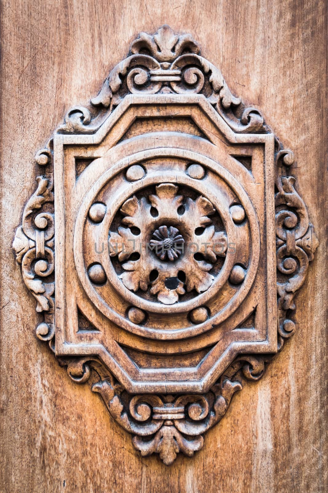 Detail of an ancient wooden door carved with geometric and floral motifs.