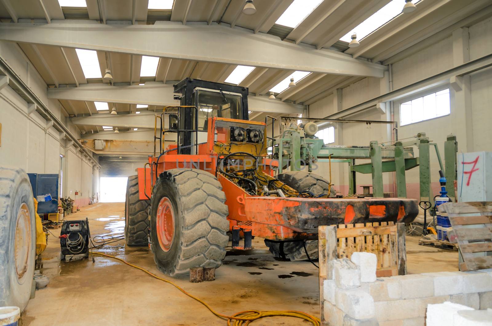 Industrial marble quarry, with cut blocks and workers and machines bulldozer at work.