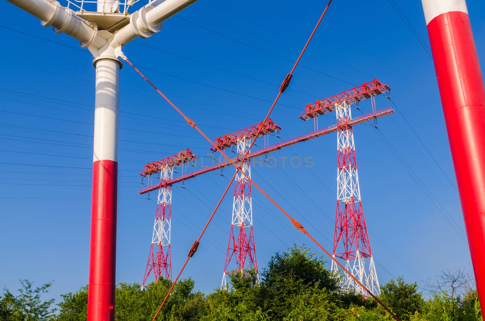 supports of high-voltage power lines against the blue sky