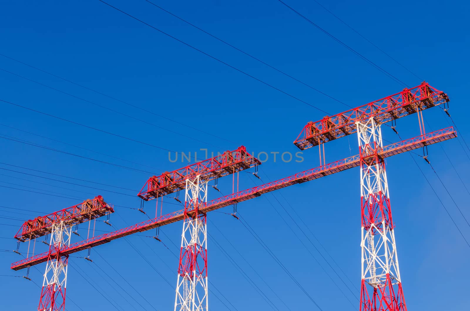 supports of high-voltage power lines against the blue sky