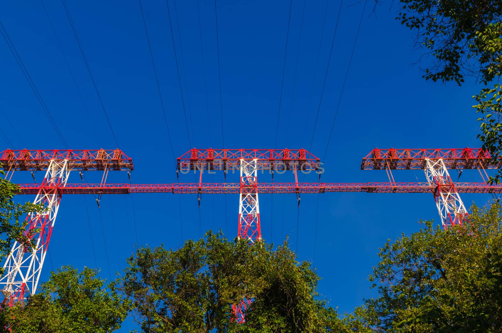 supports of high-voltage power lines against the blue sky