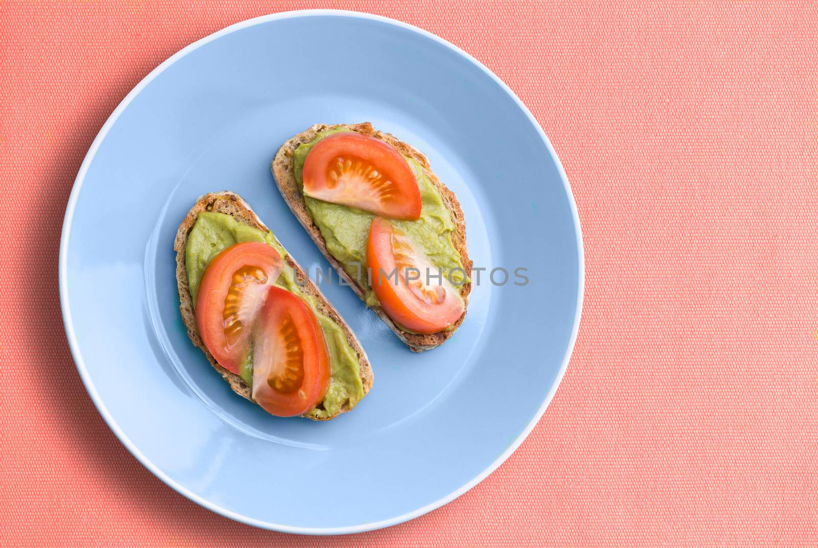 Single blue plate of avocado sandwiches by coskun