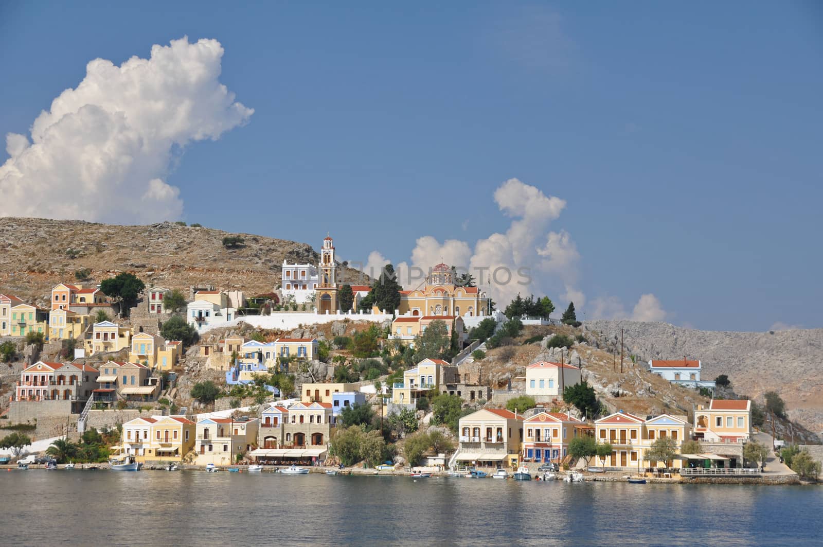 Gialos ( the lower harbour town ) and Chorio ( the upper town ) together form Symi town on the Greek island of Symi, near Rhodes in the Mediterranean sea. A quite beautiful, very tranquil, and highly colourful place. Many of the neoclassical homes were built by wealthy sponge merchants in the 19th century.