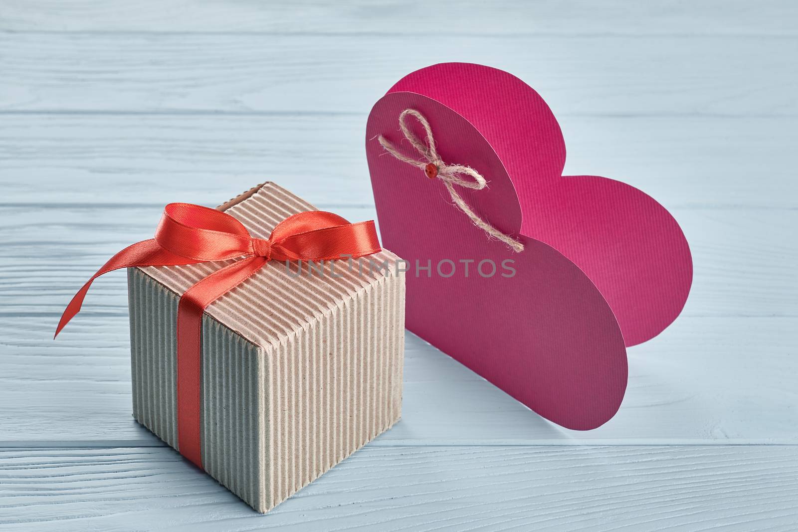 Valentines Day. Love heart, gift box, red ribbon handmade  paper card. Vintage retro romantic style. Marriage proposal concept. Unusual creative greeting card, wooden blue background, copyspace, toned