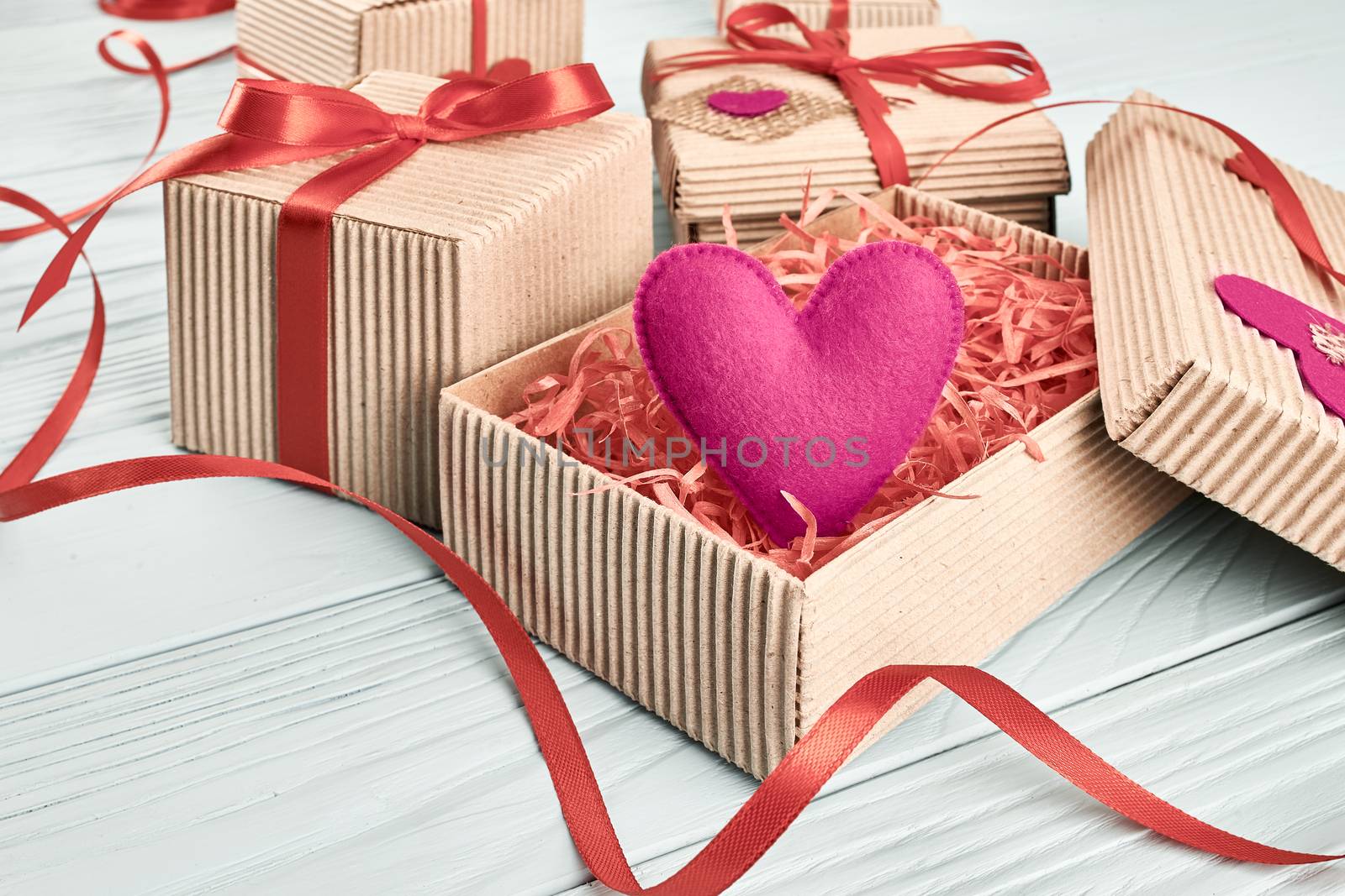Valentines Day. Love hearts, gift boxes, presents stack. Handmade pink heart, red ribbons felt. Vintage retro romantic styled. Unusual creative art greeting card, wooden blue background, copyspace