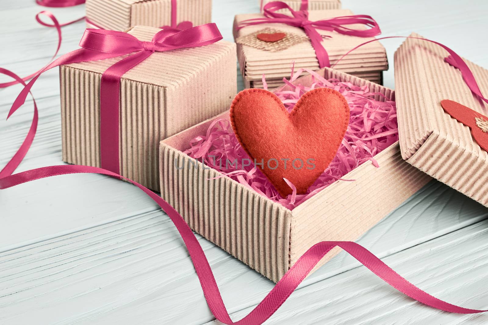 Valentines Day. Love hearts, gift boxes, presents stack. Handmade red heart, ribbons felt. Vintage retro romantic styled. Unusual creative art greeting card, wooden blue background, copyspace