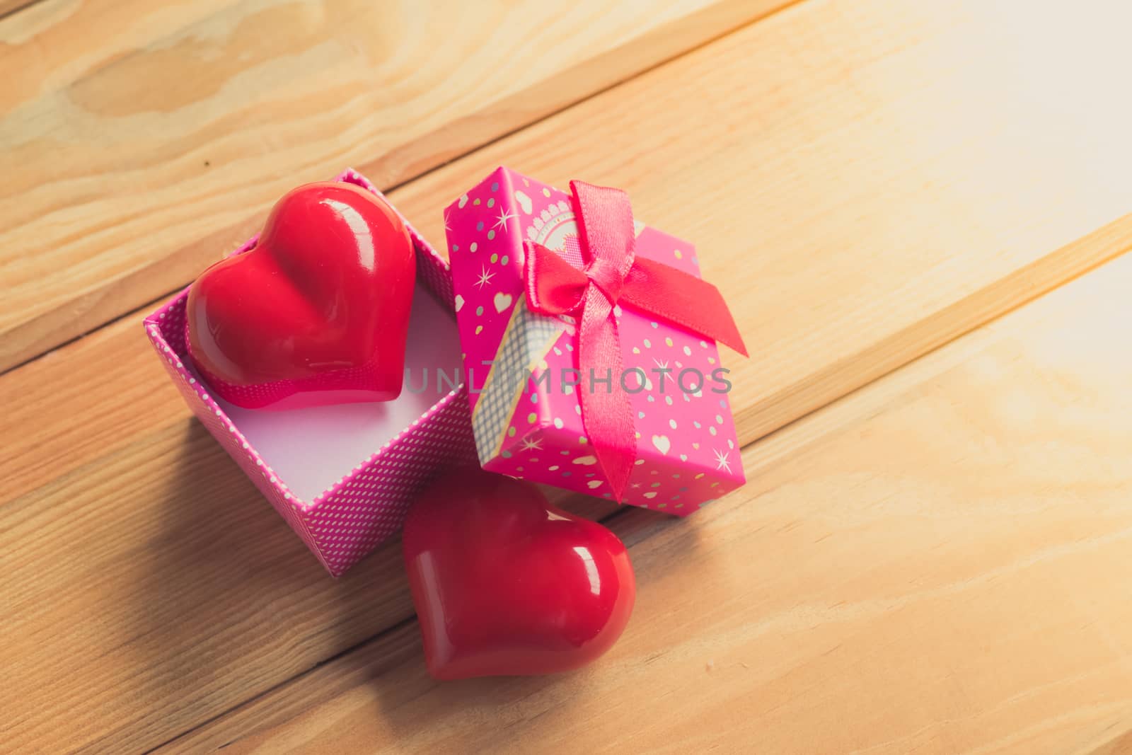 Gift of love. hearty gift. A gift box with a red heart inside. On the wooden floor