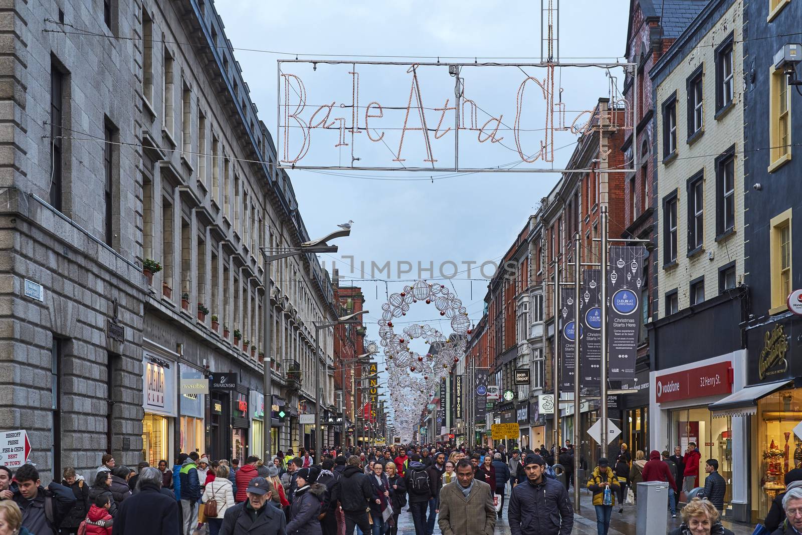 DUBLIN, IRELAND - JANUARY 05: Busy Henri Street full of pedestrians after the rain. The sign reads 'Baile Átha Cliath', Irish Celtic for 'Dublin'. January 05, 2016 in Dublin