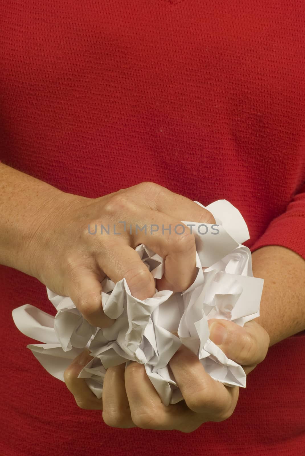 Vertical shot of woman crumpling paper.