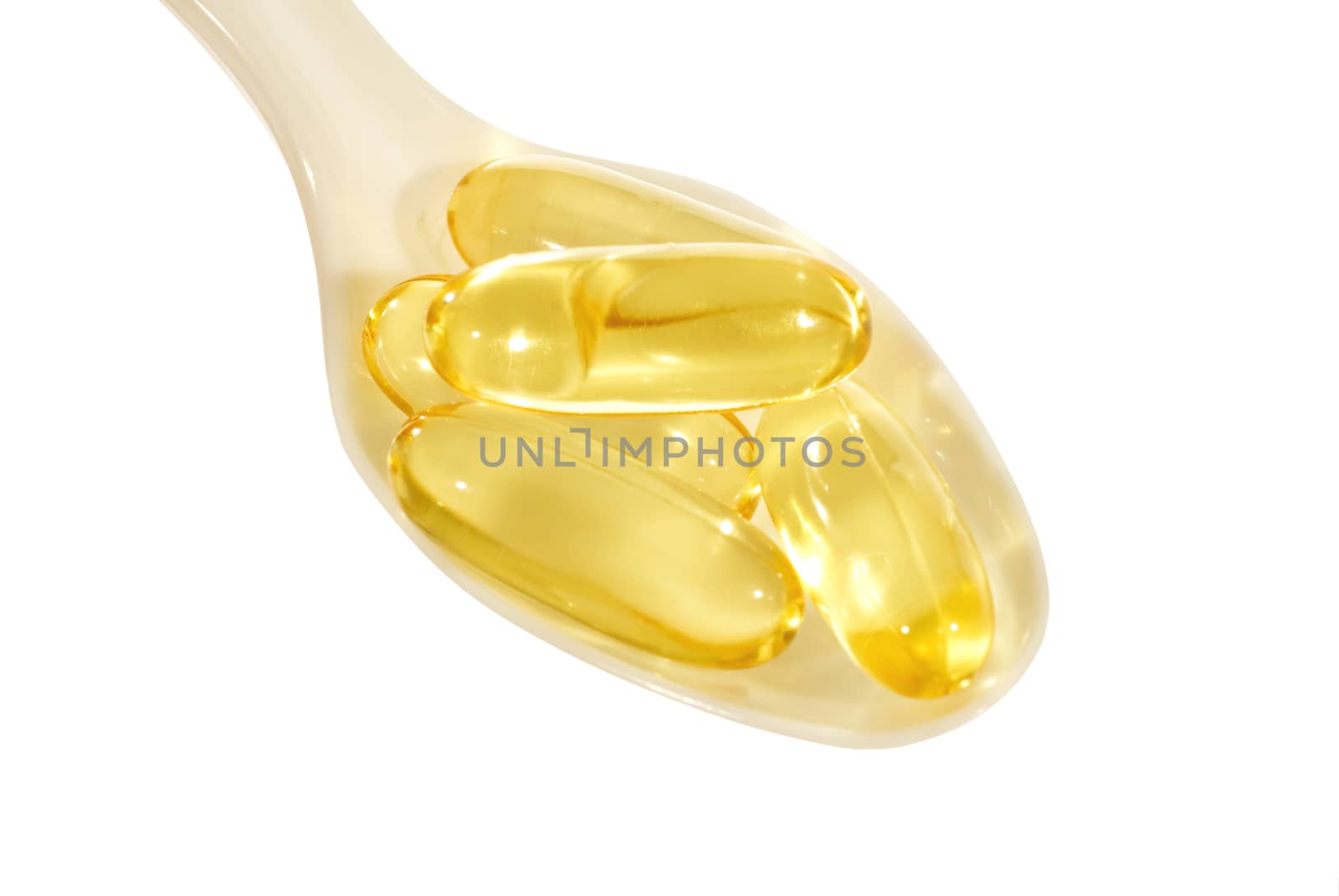 Overhead shot of vitamins in a spoon and shot on a white background.  Lots of copy space.