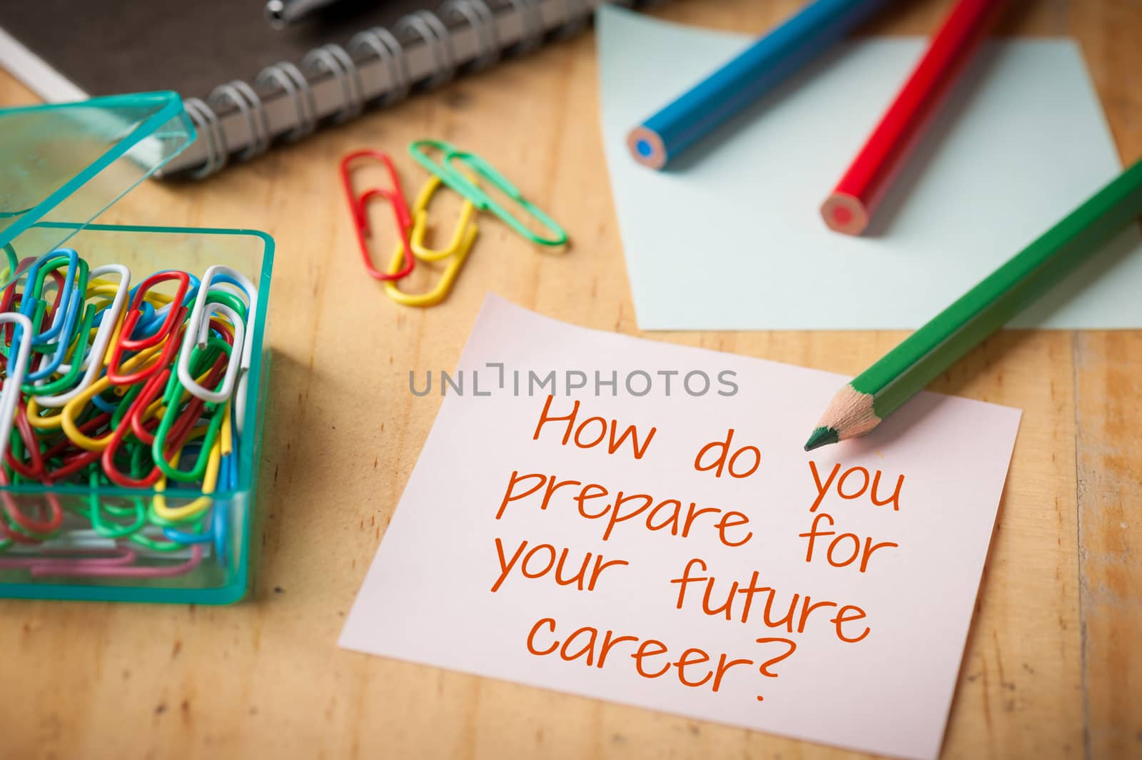 "How do you prepare for your future career" is written on sticky paper with paper clip, color pencil, and pen on wood table