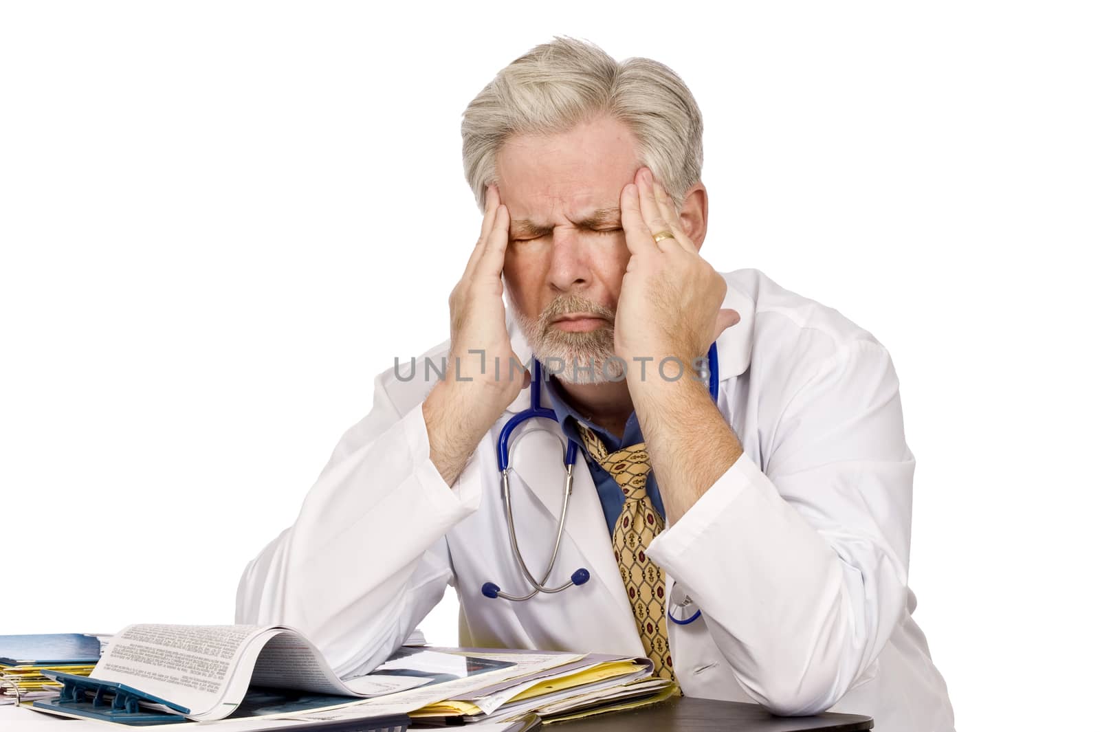 Horizontal shot of a tired doctor at his desk with a bad headache.