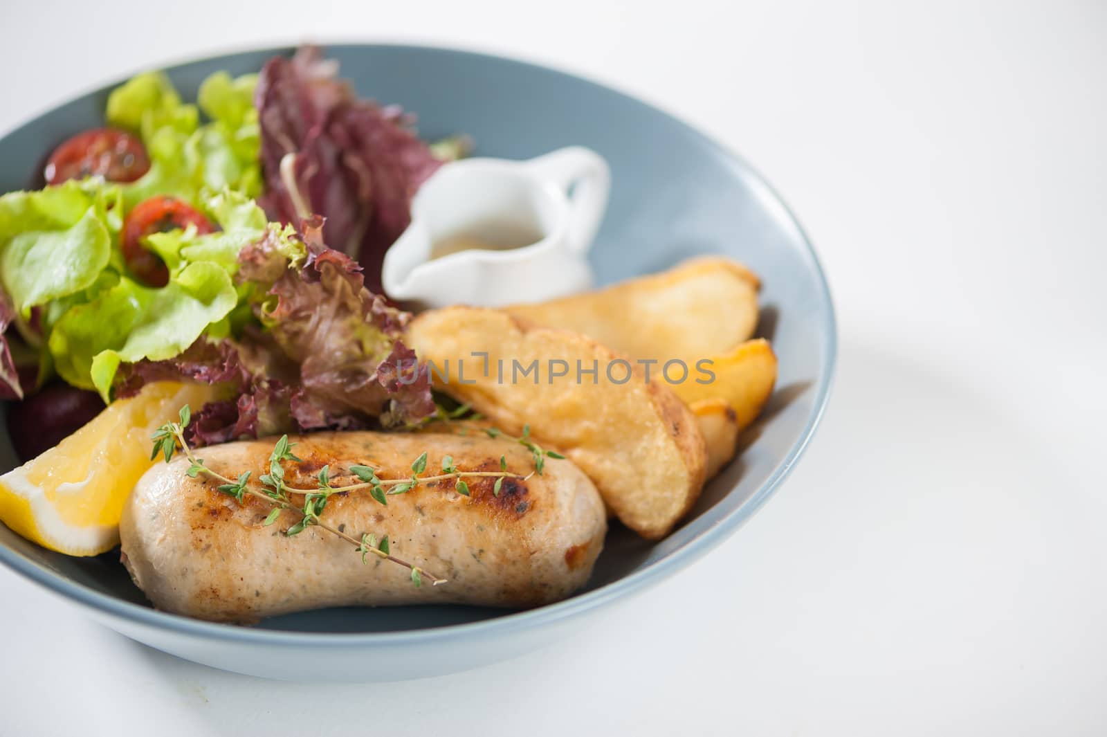 Grilled sausage with fried potatoes and salad