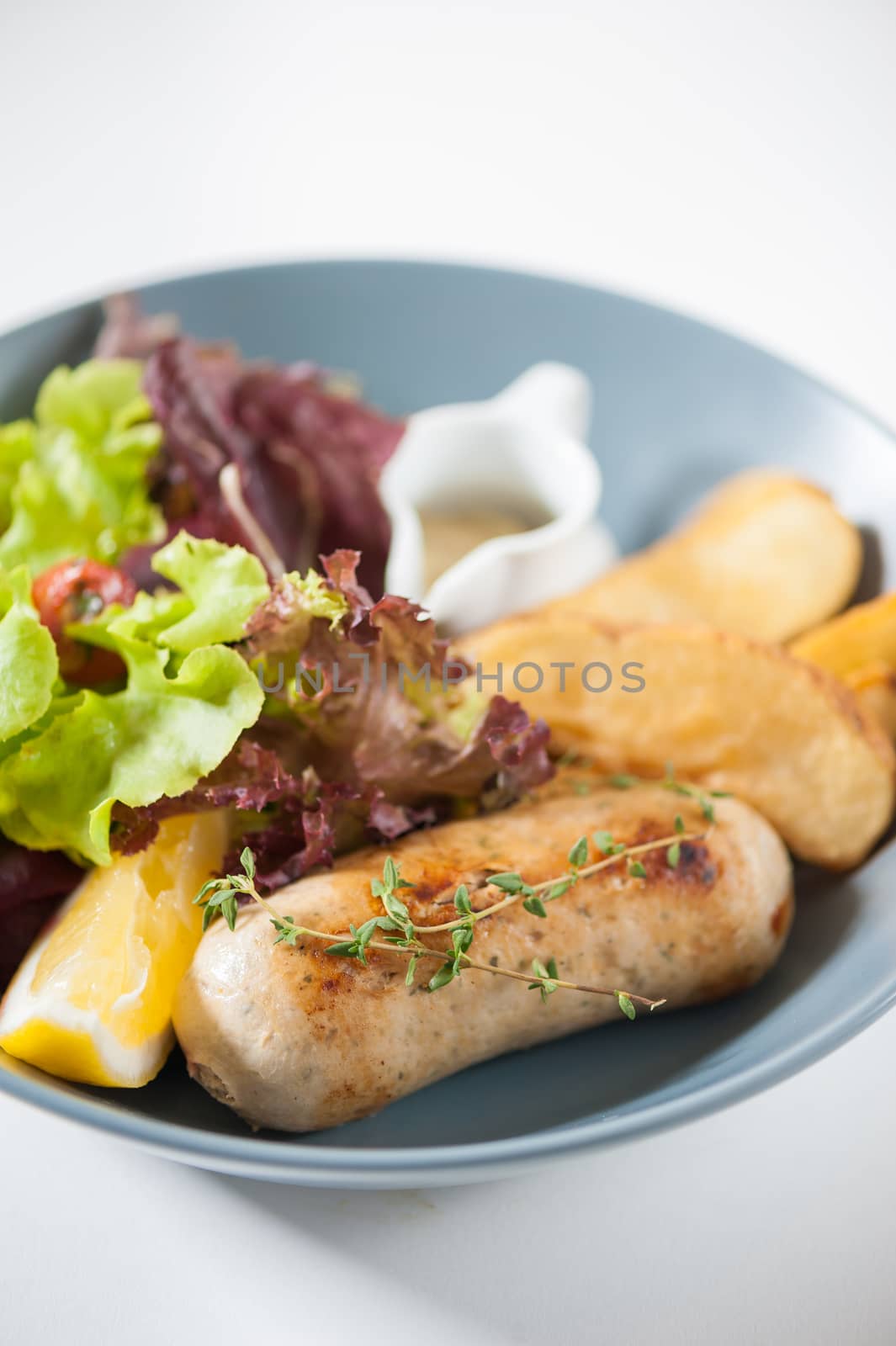 Grilled sausage with fried potatoes and salad