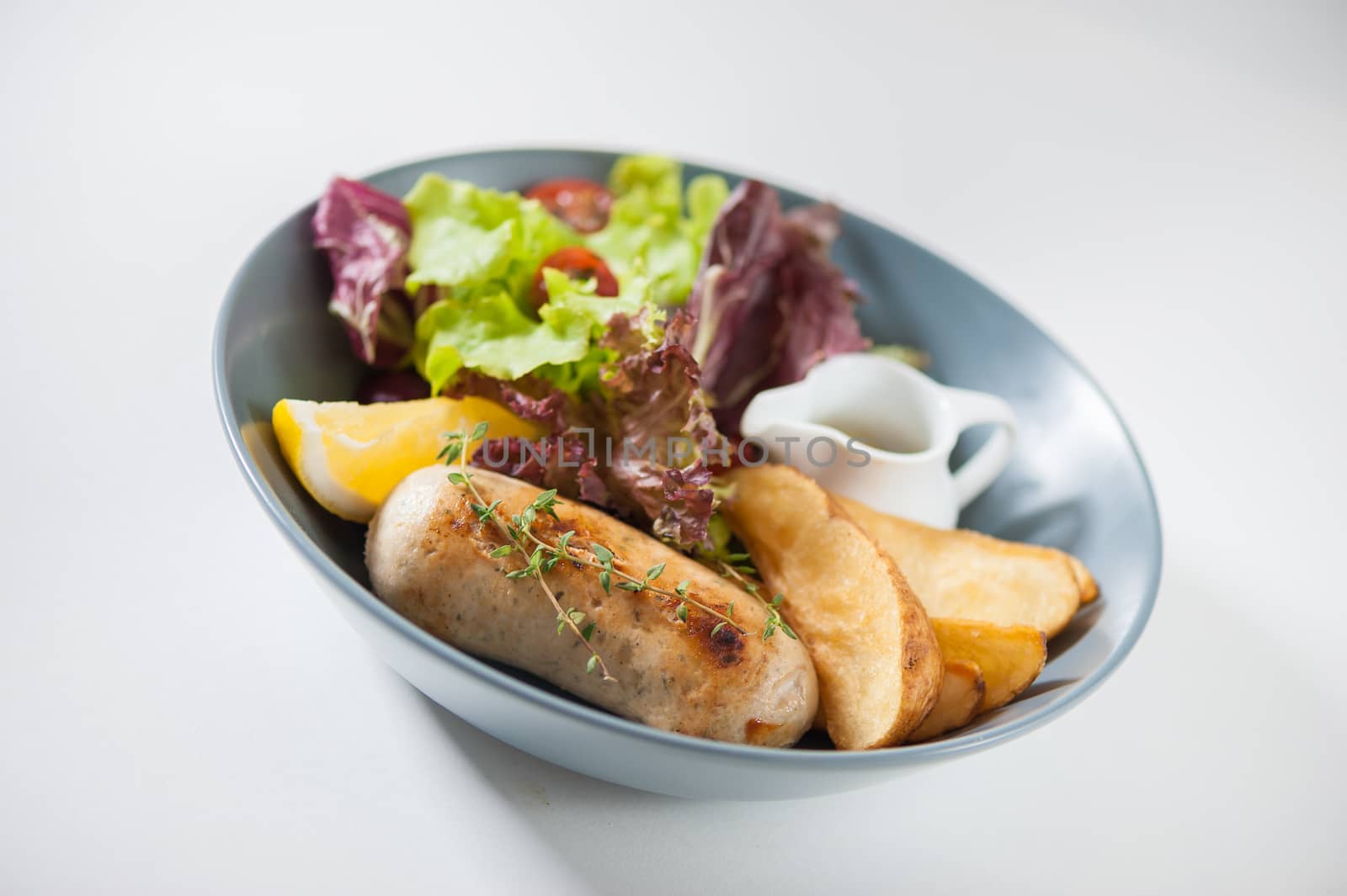 Grilled sausage with fried potatoes and salad