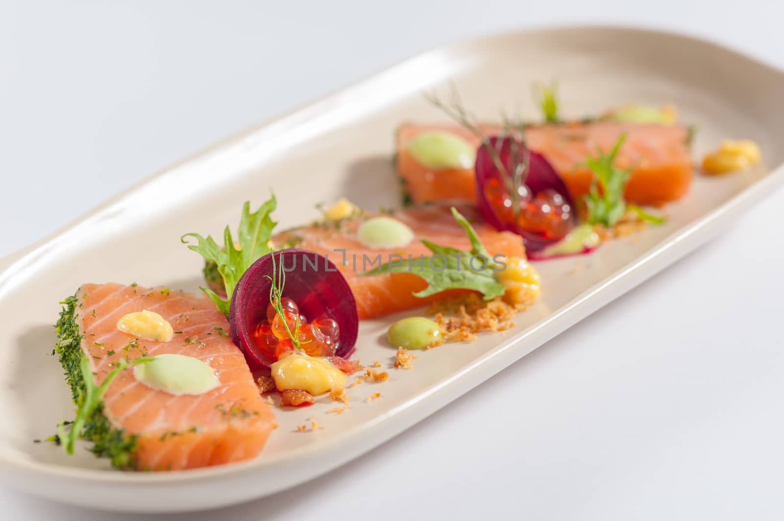 Smoked salmon with herbs, beetroot, faked salmon roe (sauce cooked by molecular gastronomy technic) garnished with mago sauce and wasabi mayo