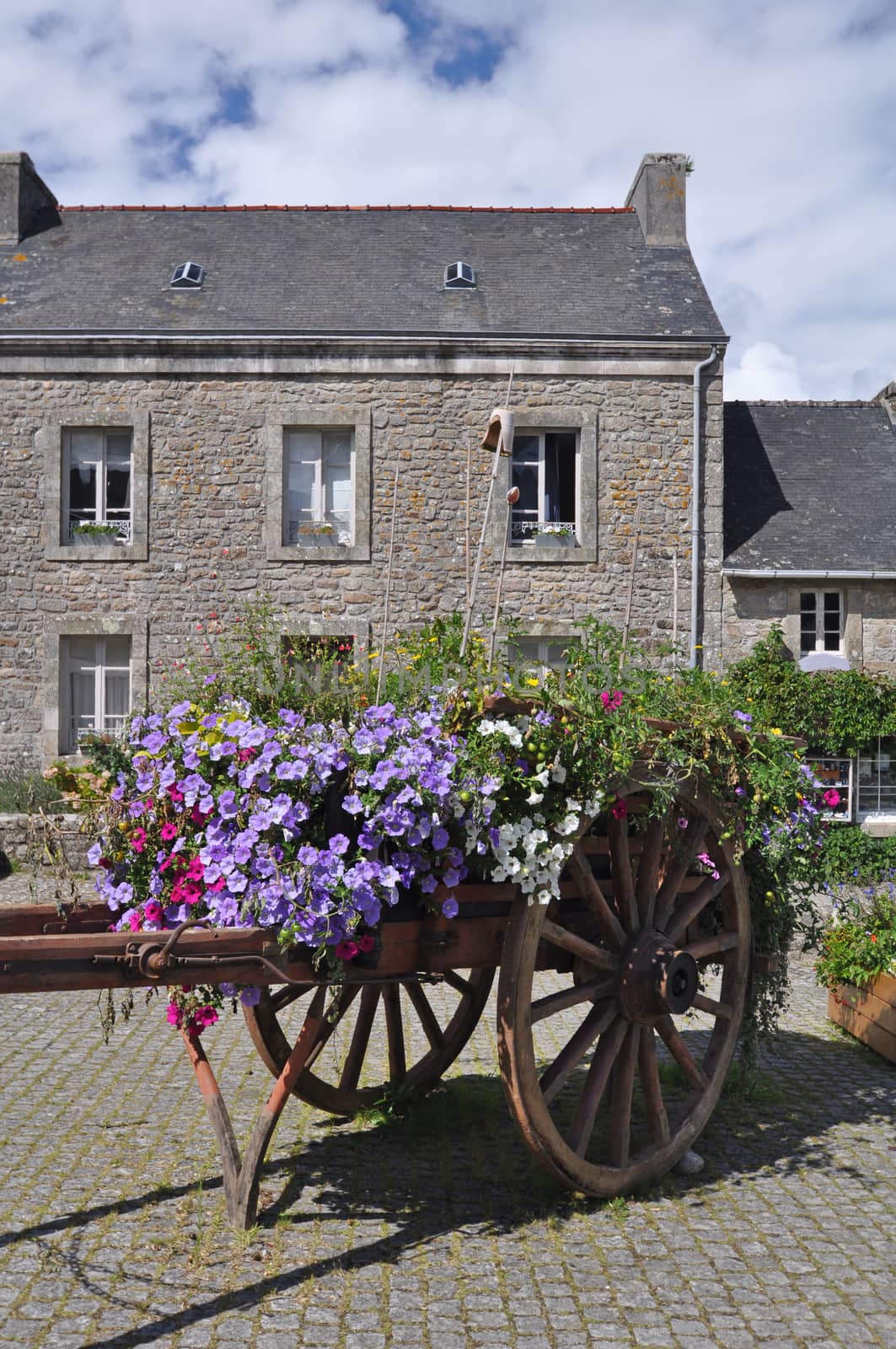Floral display in an old wooden cart, in the village of Locronan, in Brittany, rural France