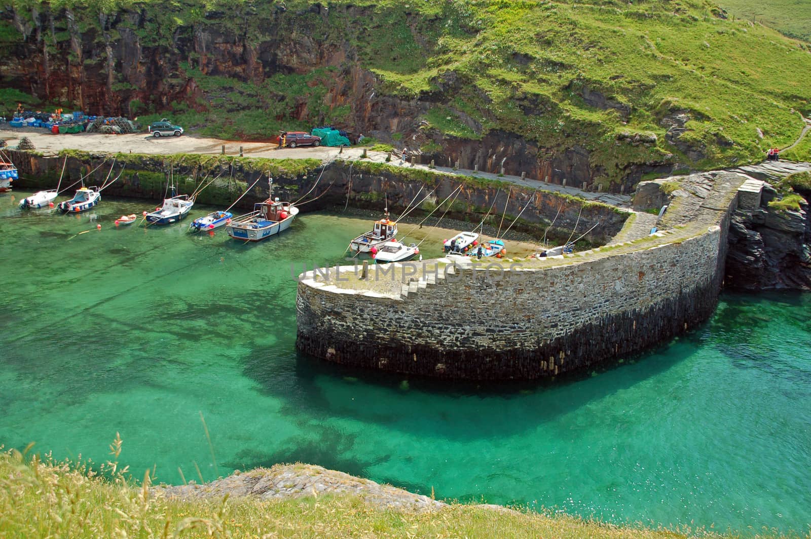 The village of Boscastle site on the Atlantic coast in north Cornwall, in the southwest of England. The little village has a small fleet of little fishing boats seen here behind the harbour wall. Boscastle here is a tranquil idylic place but some years ago it made global news when a flash flood washed much of the village away. Today it is once again a wonderfully peacefuland picturesque place to visit 